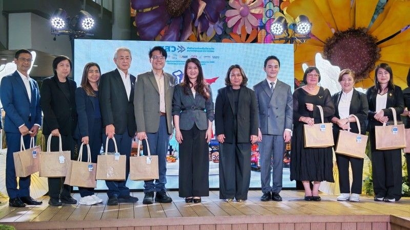 Professionals hold tote bags on stage in front of a screen displaying "DBP Sustainable SDG."