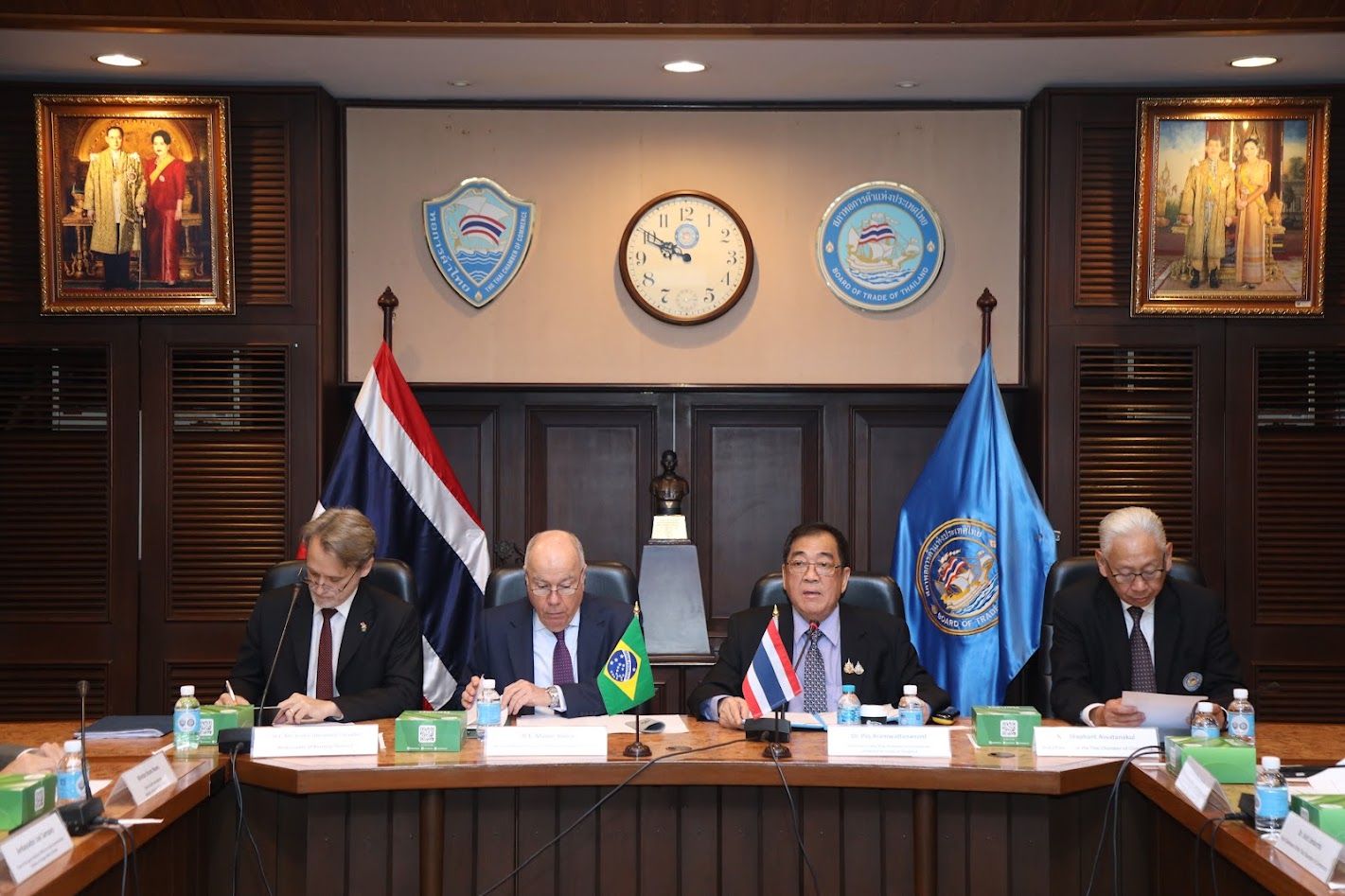 Four officials from Thailand and Brazil are seated at a long conference table during a formal meeting.