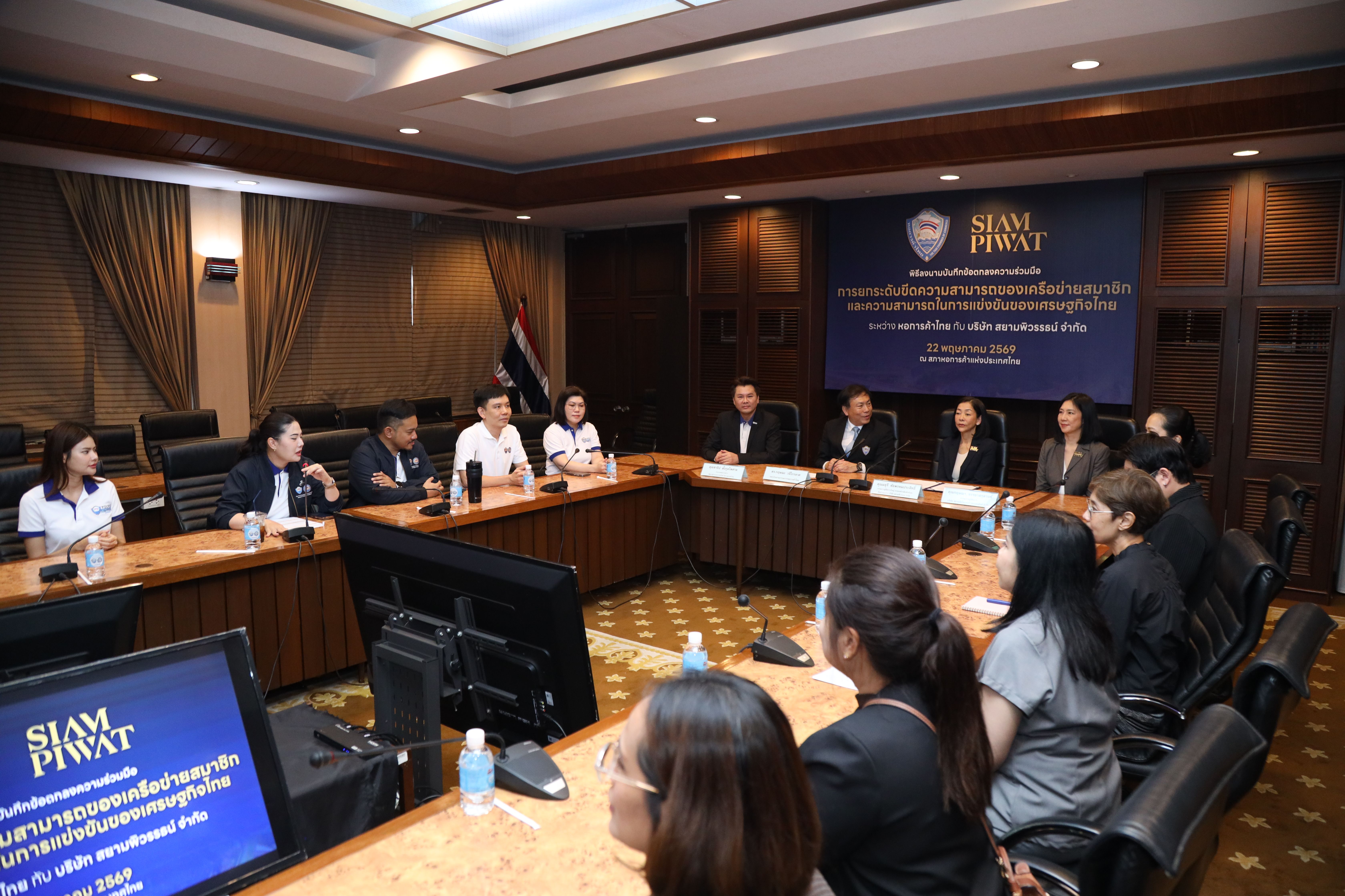 Professionals attend a meeting in a well-lit conference room with Siam Piwat branding.