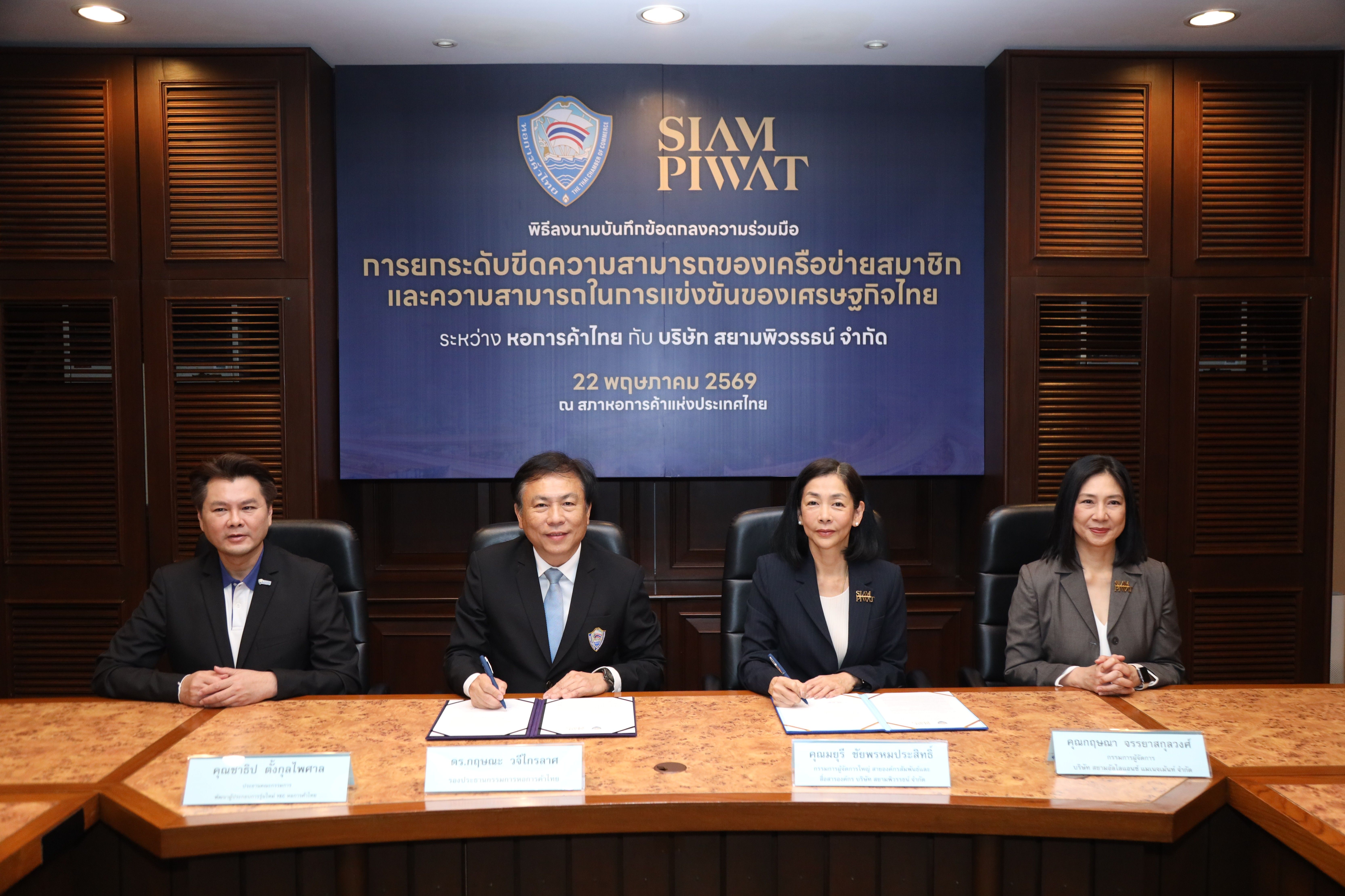 Four executives sign documents at a conference table with a prominent Siam Piwat banner.