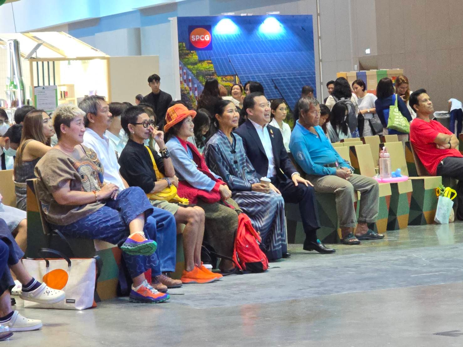 Diverse group of people sitting and watching a presentation at an indoor event.