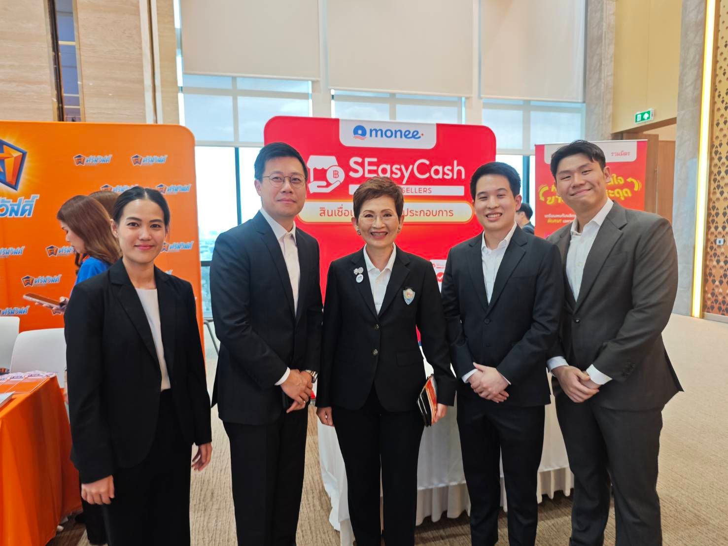 Five business executives in suits pose in front of a Shopee SEasyCash banner.