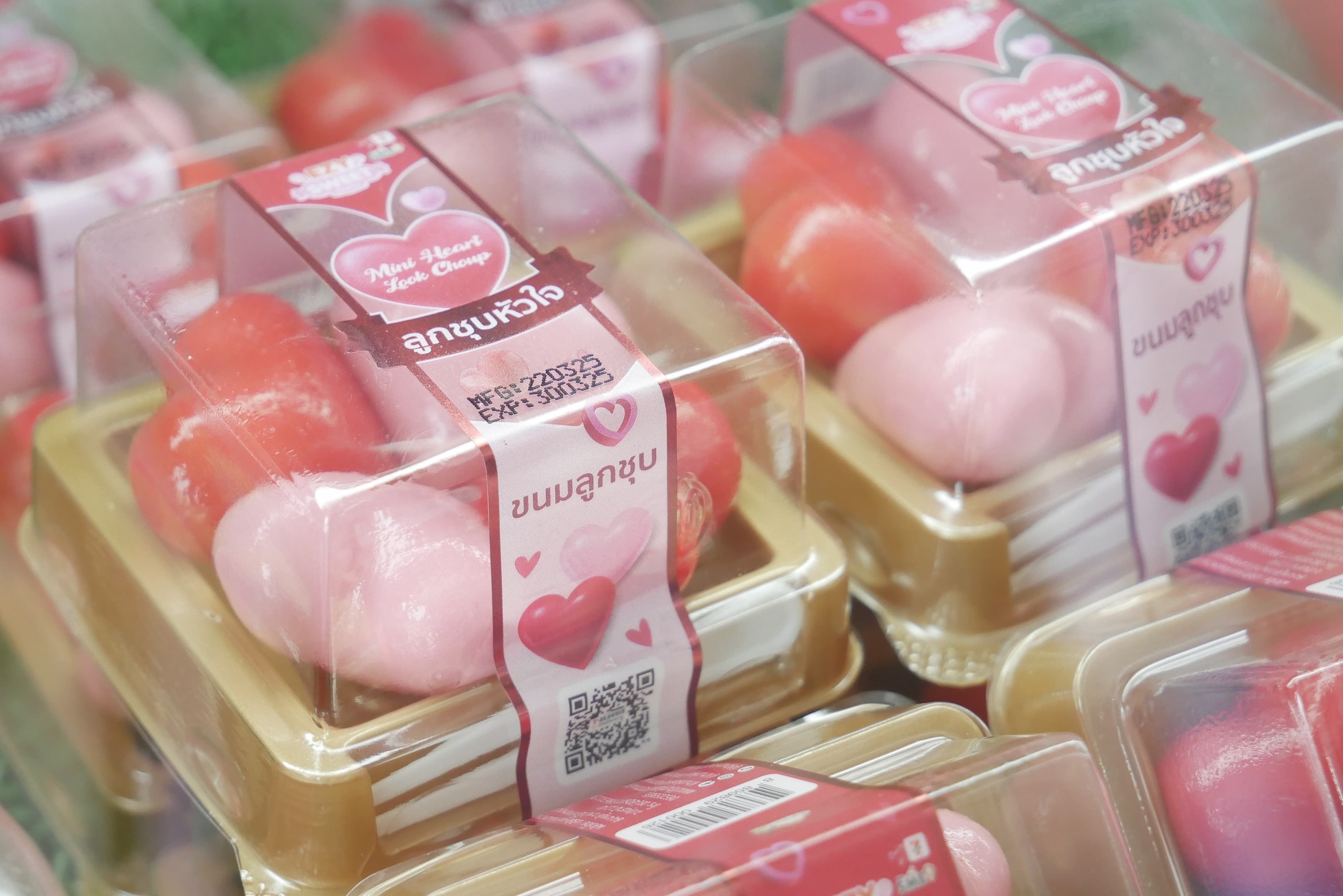Pink and red heart-shaped soaps or bath bombs packaged for Valentine's Day gifts.