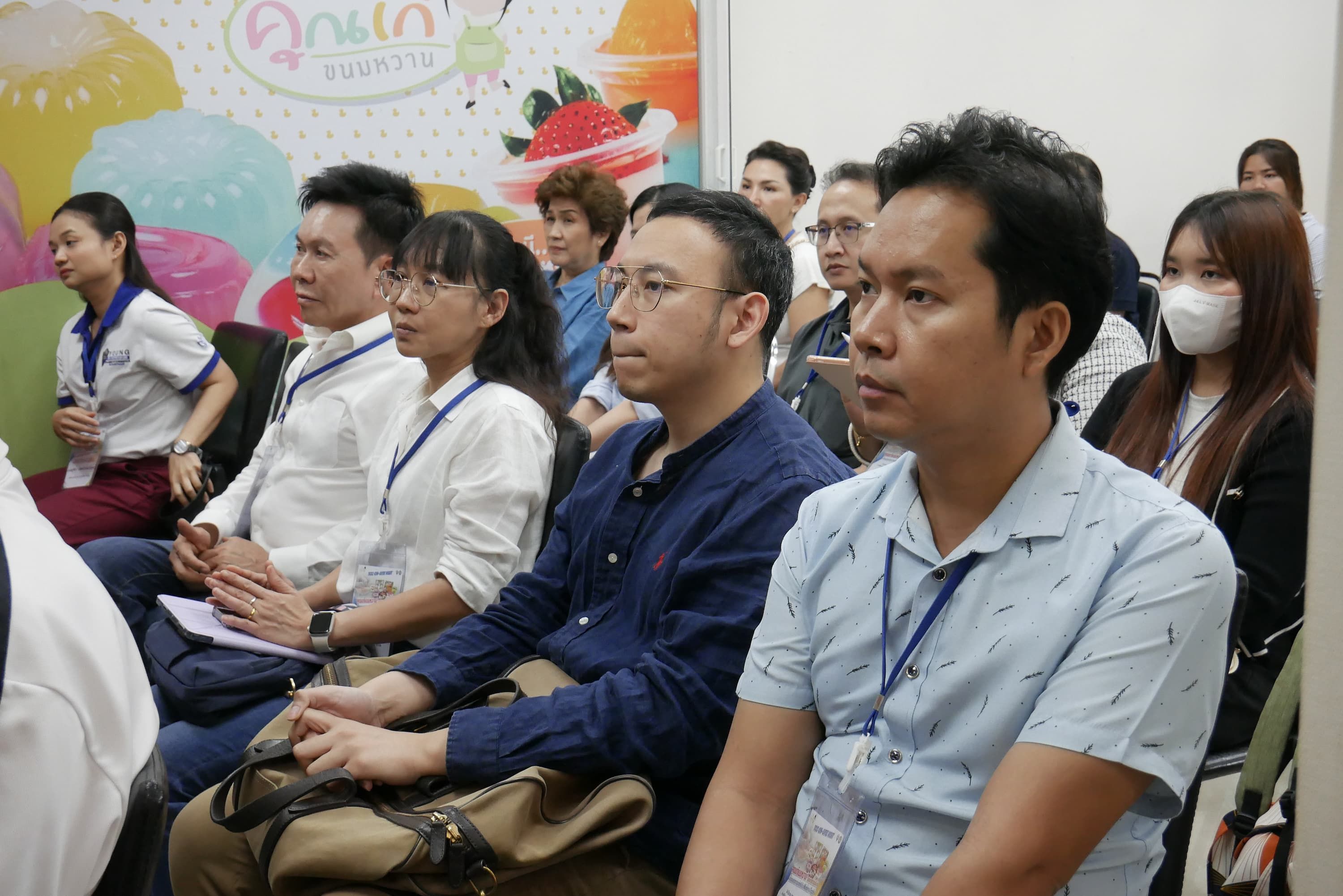 Diverse audience members attentively listen during a professional seminar or conference.