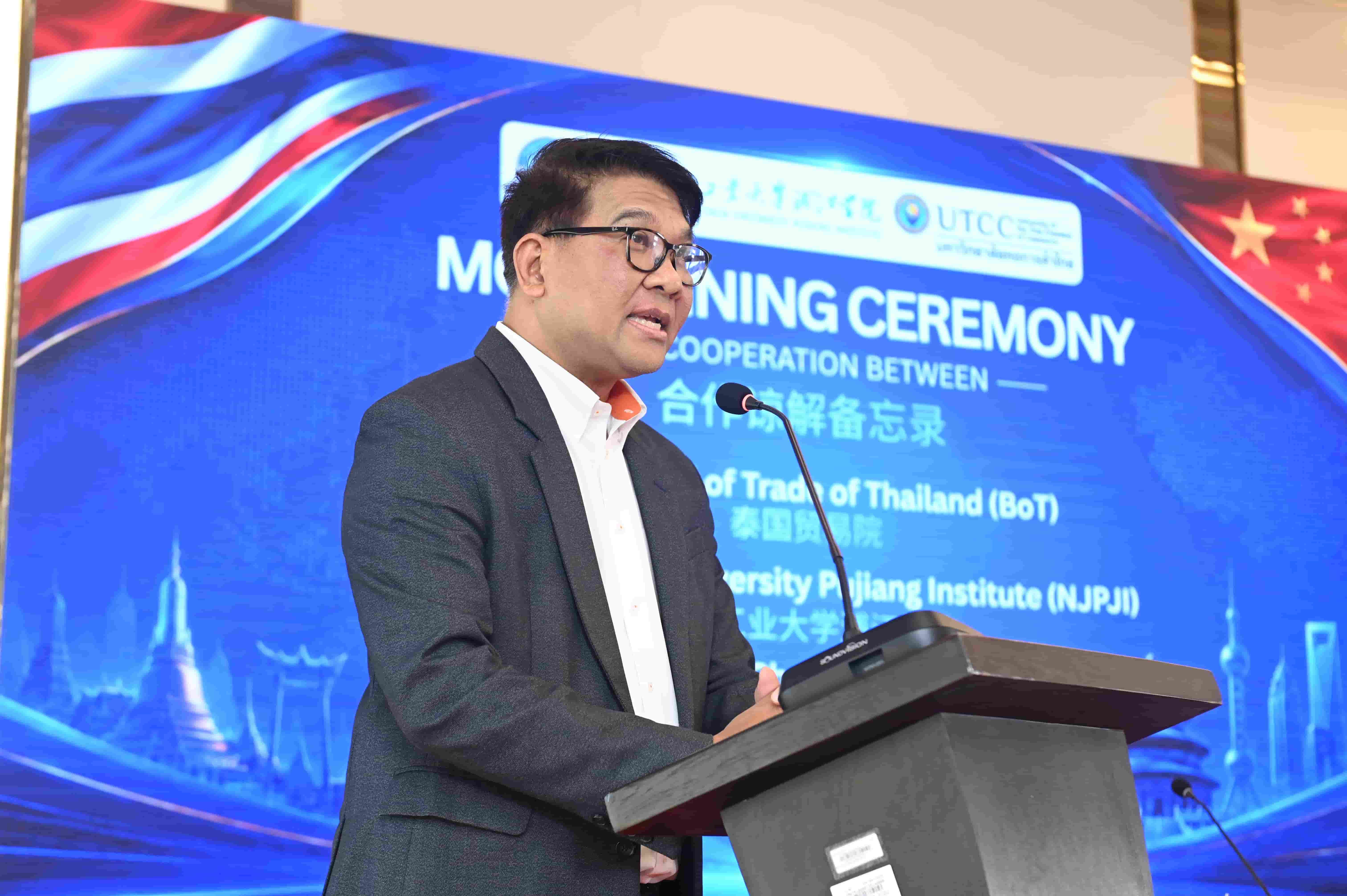 Man in glasses speaking at a podium during a morning cooperation ceremony.
