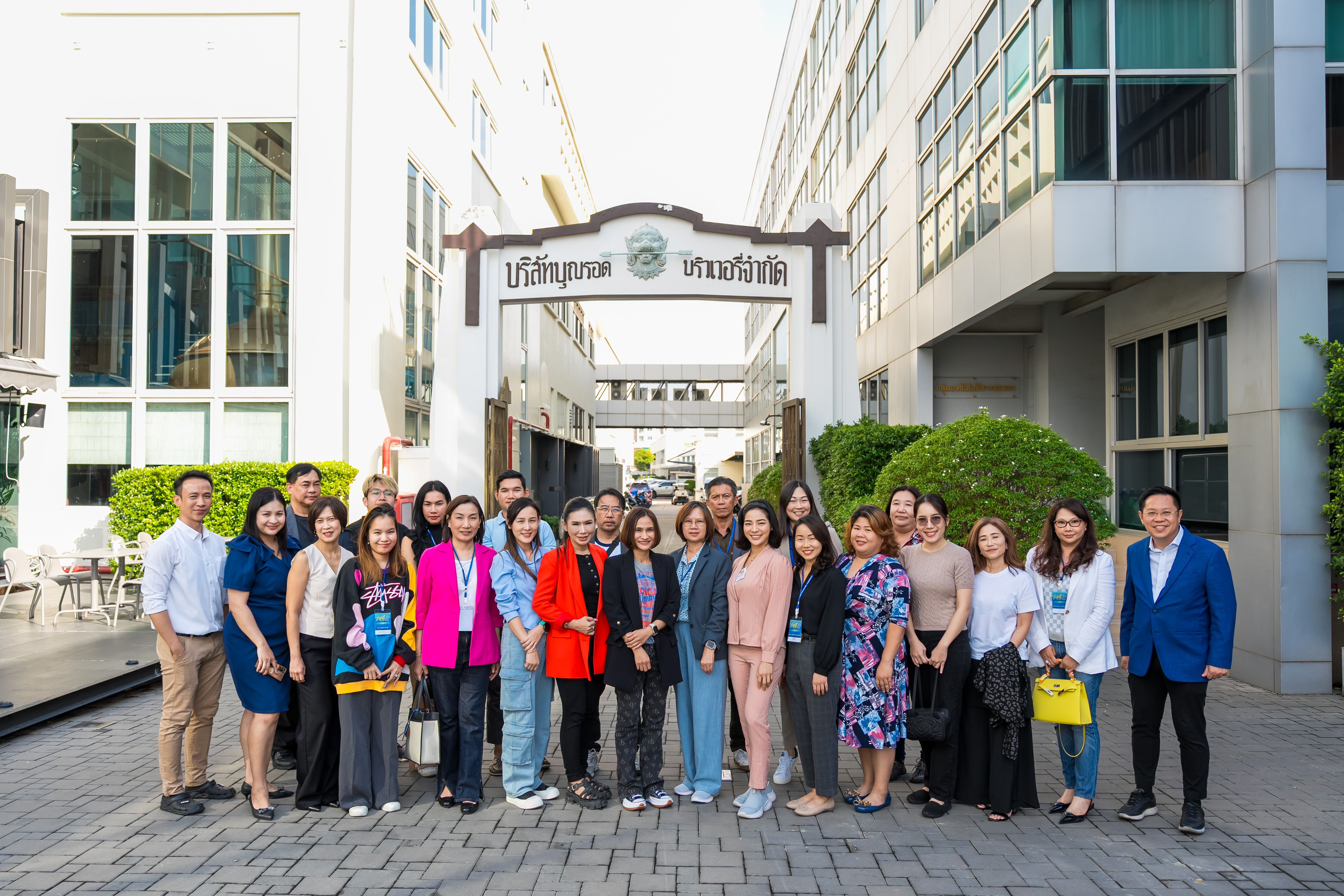 Group of professionals posing in front of a building with an arched sign.