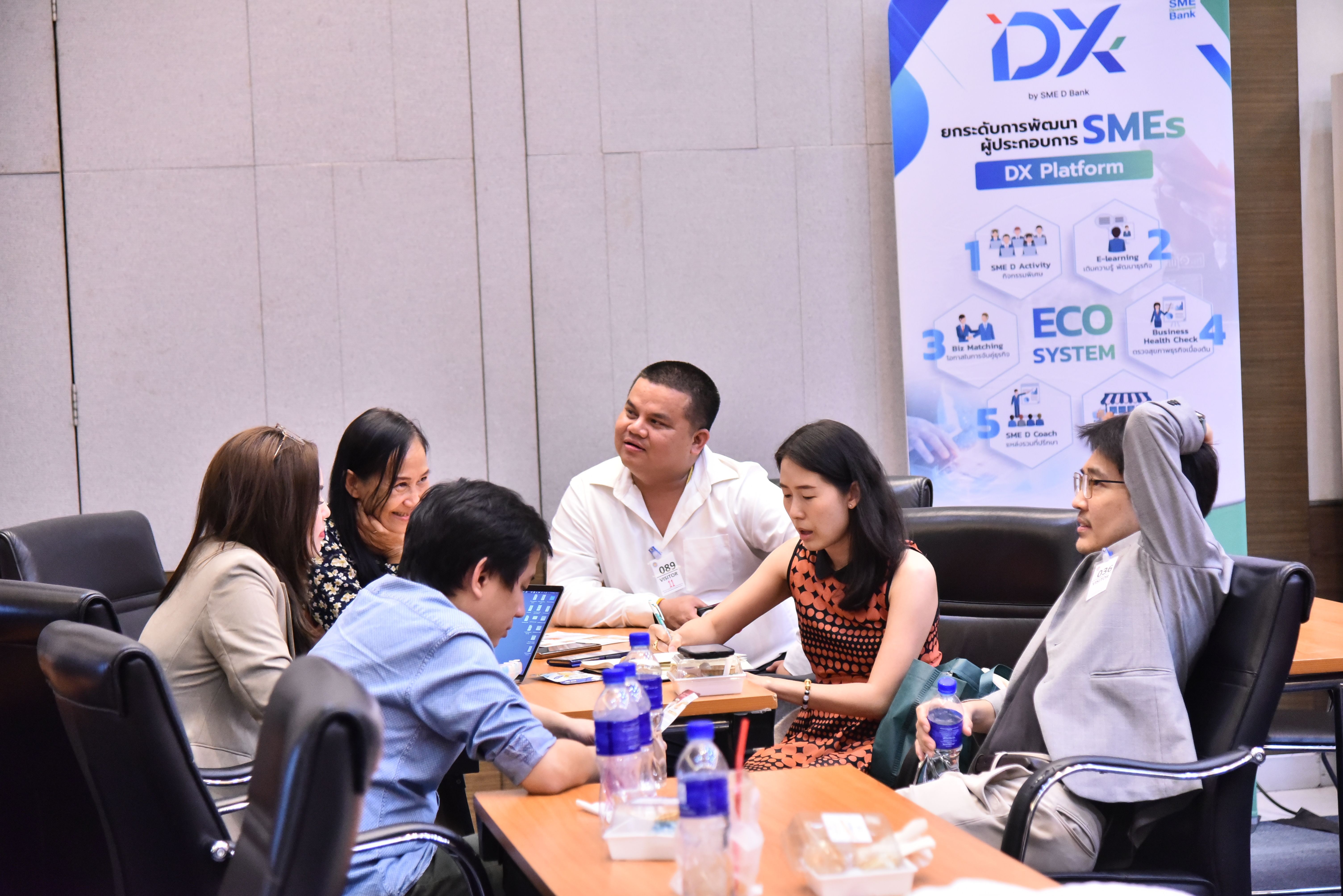 Group of diverse professionals discussing around a conference table with a 'DX Platform' banner.