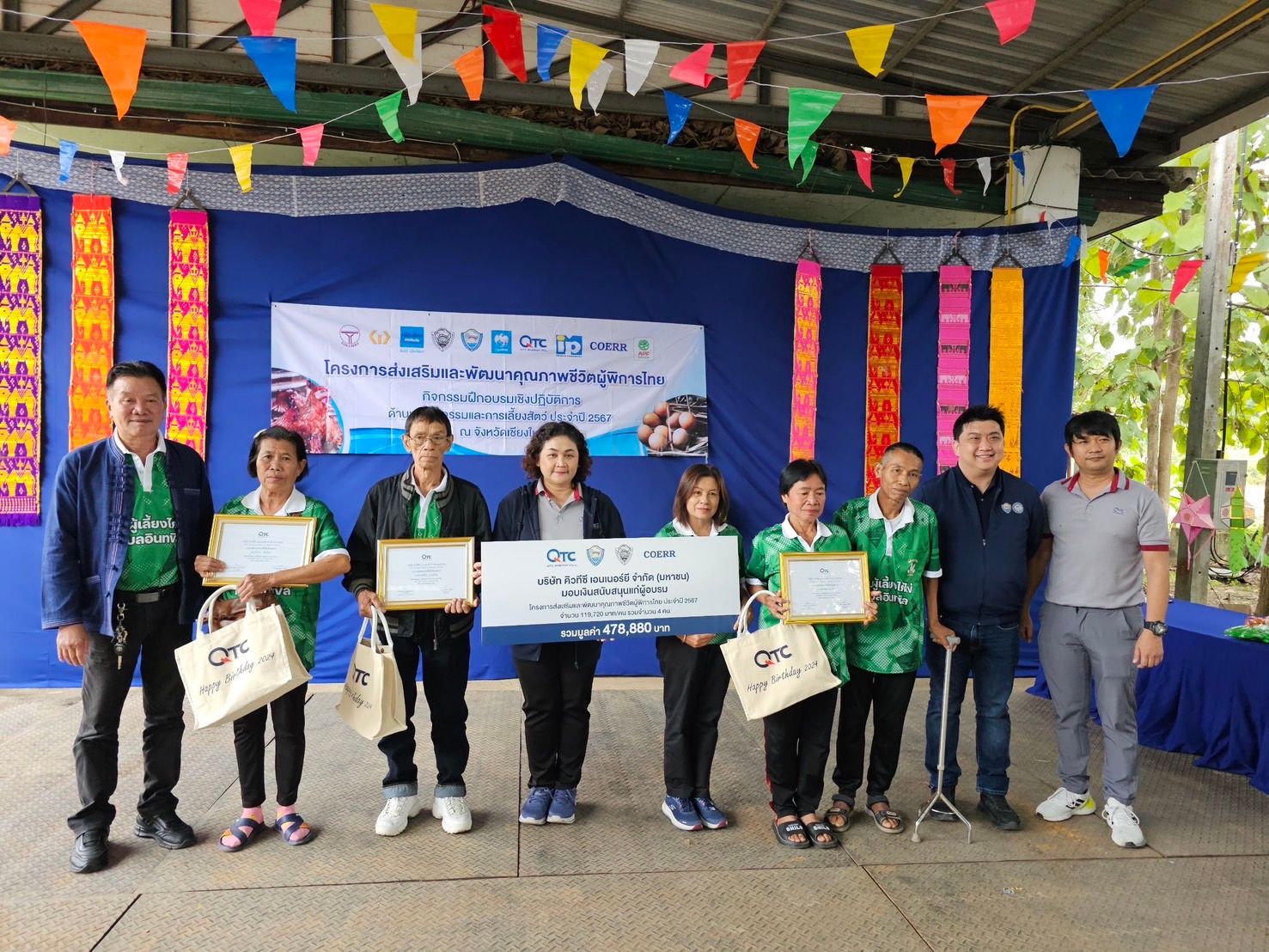 Group of people receiving certificates and awards in front of an event banner.