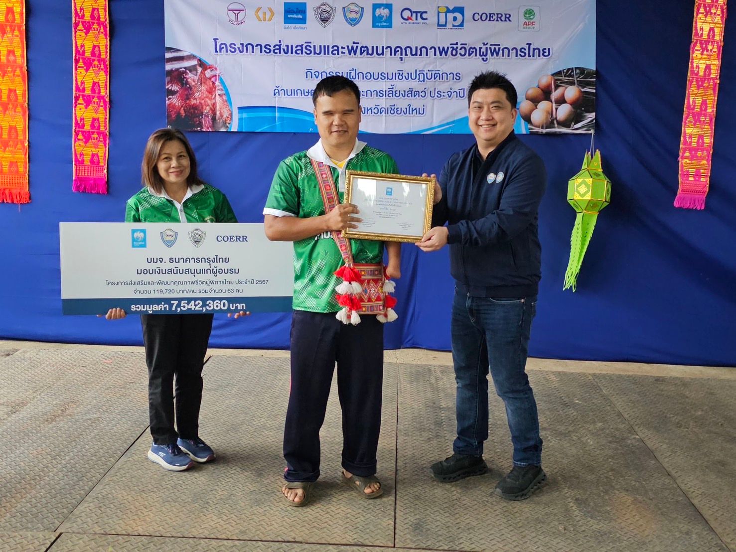 A man receives a certificate from another man, while a woman holds an oversized check.