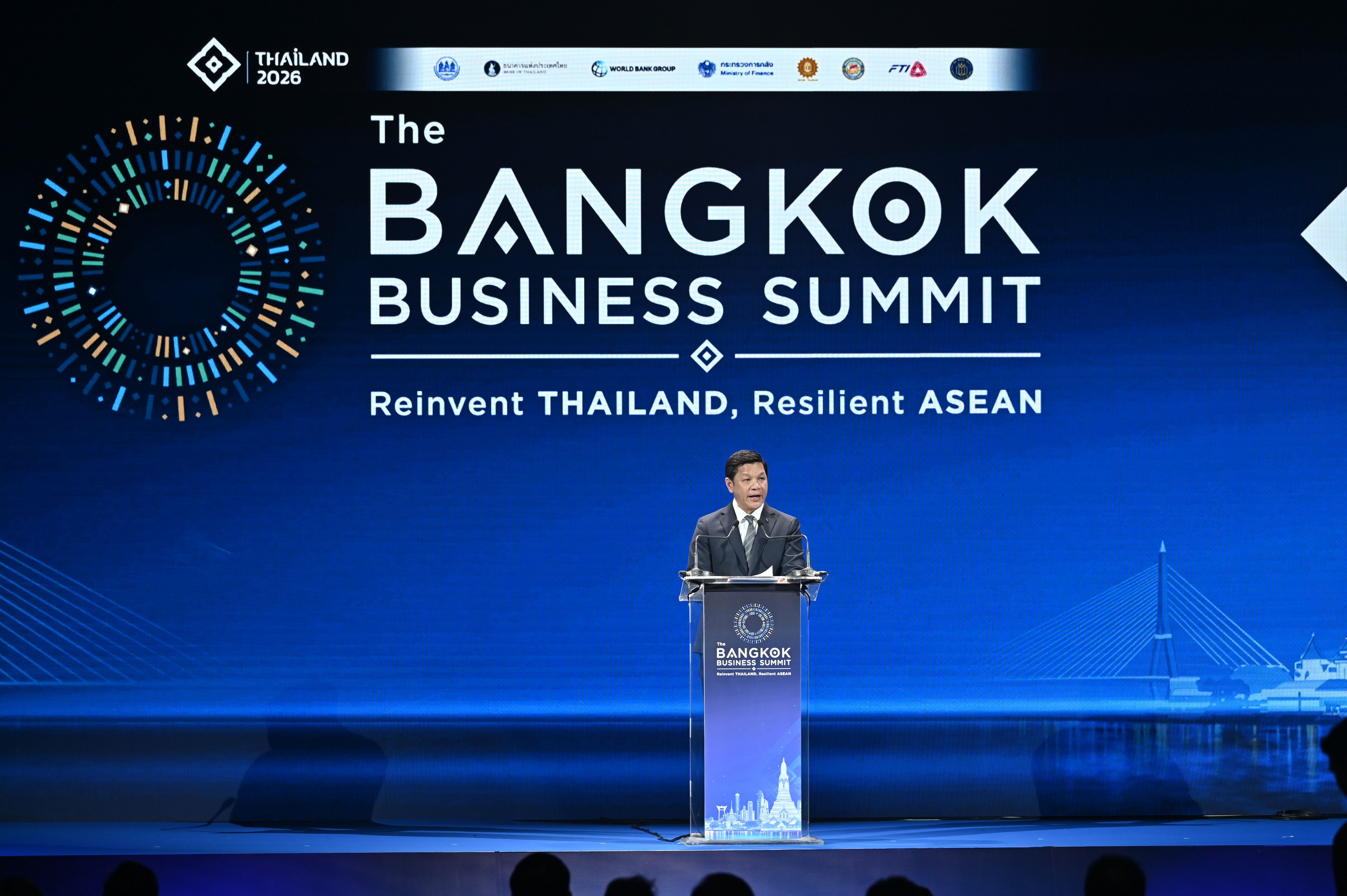 Man speaks at podium during The Bangkok Business Summit, reinventing Thailand.