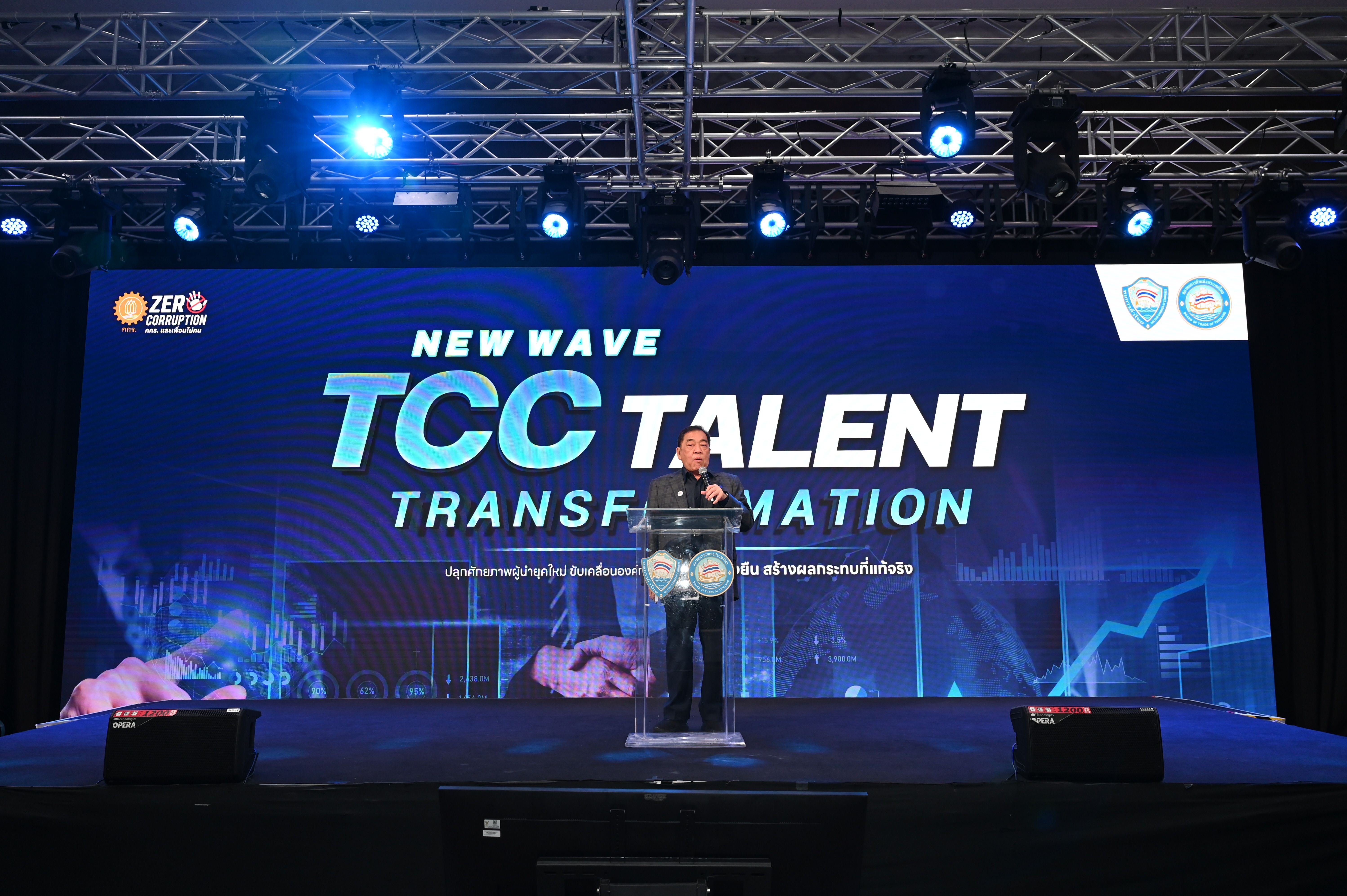 Speaker on stage with 'NEW WAVE TCC TALENT TRANSFORMATION' displayed on a large screen.
