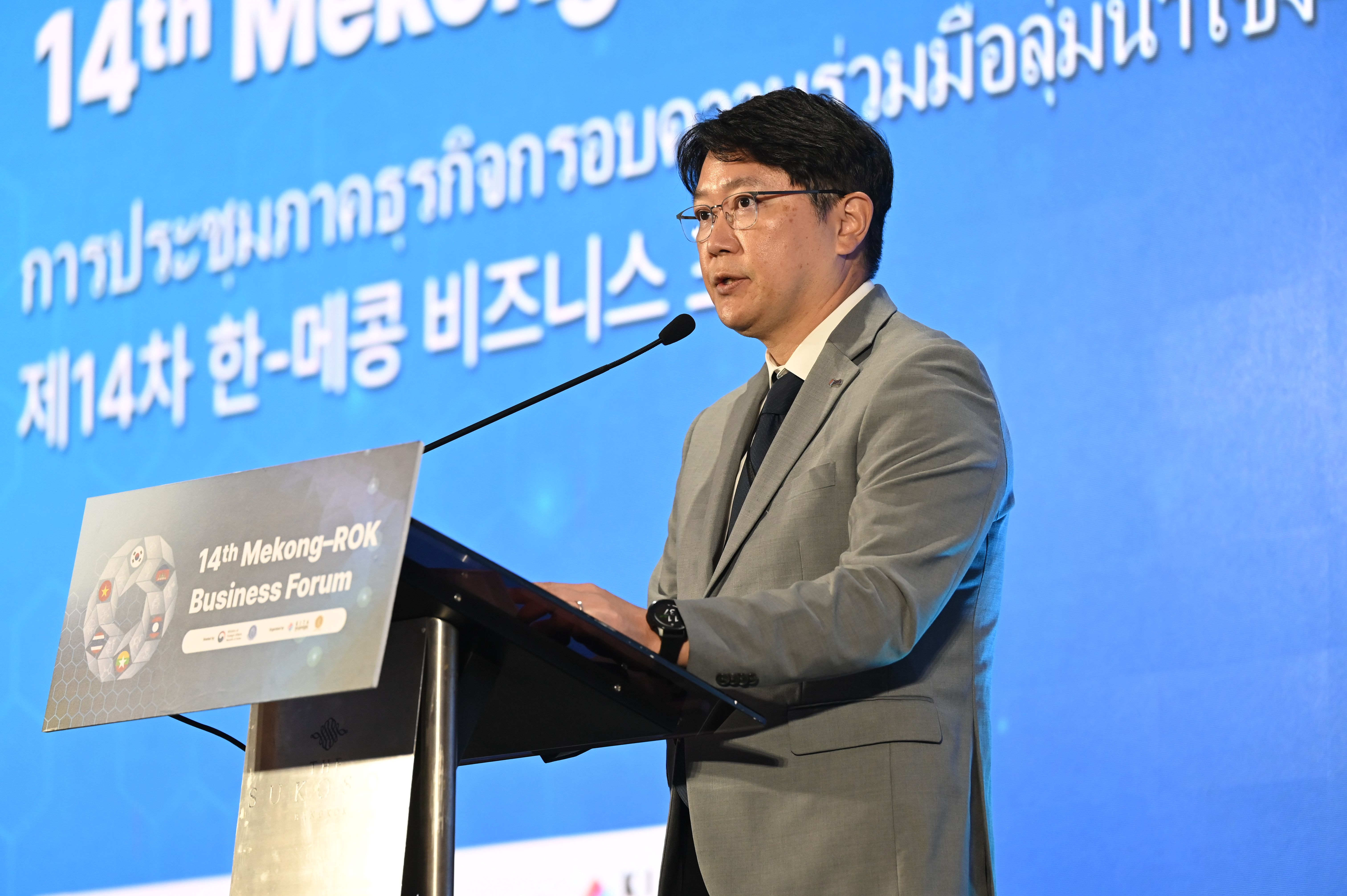 A man in a suit speaks at a podium during the 14th Mekong Business Forum.