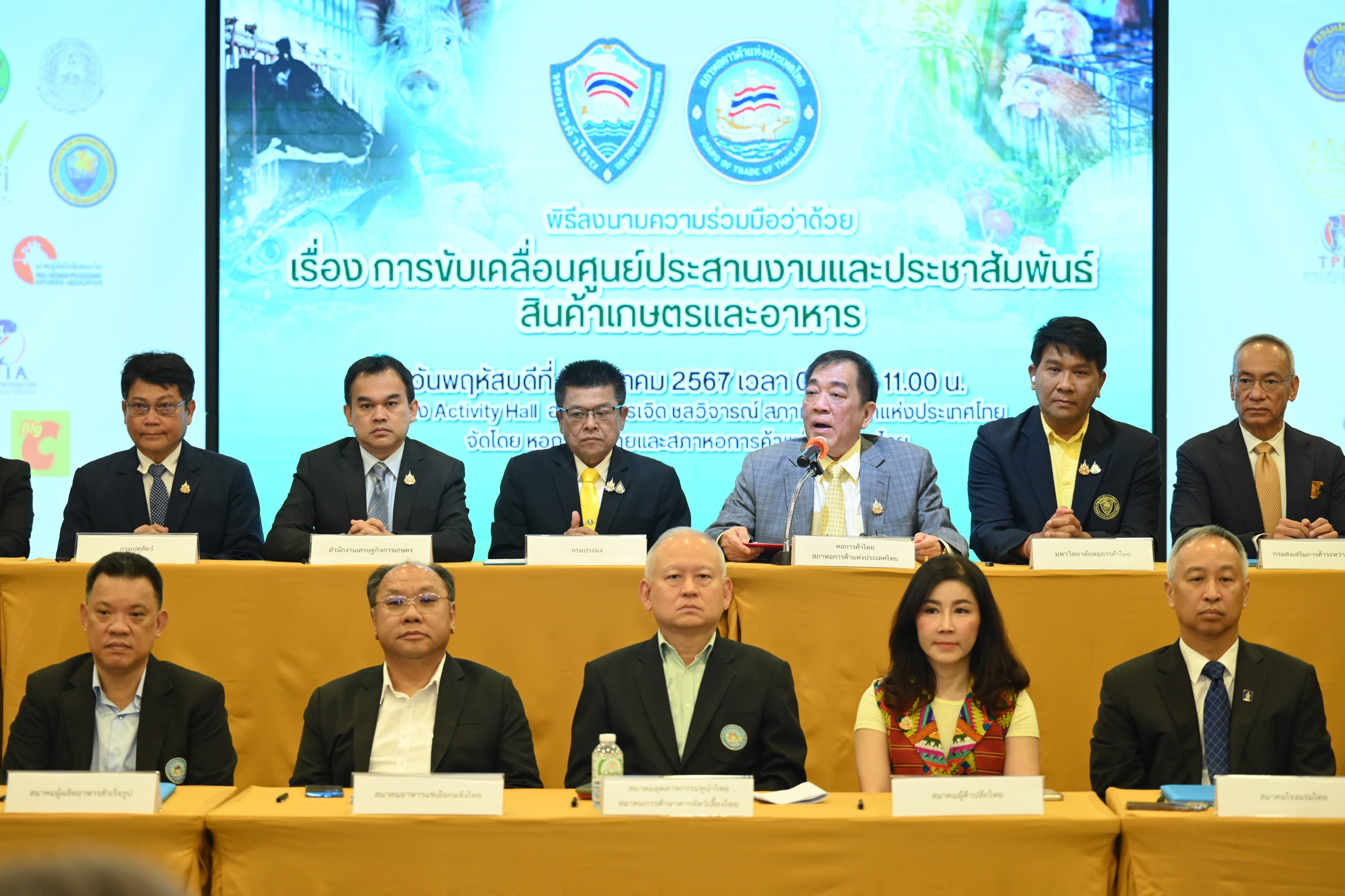 Group of distinguished individuals attending a formal meeting or conference with a branded backdrop.