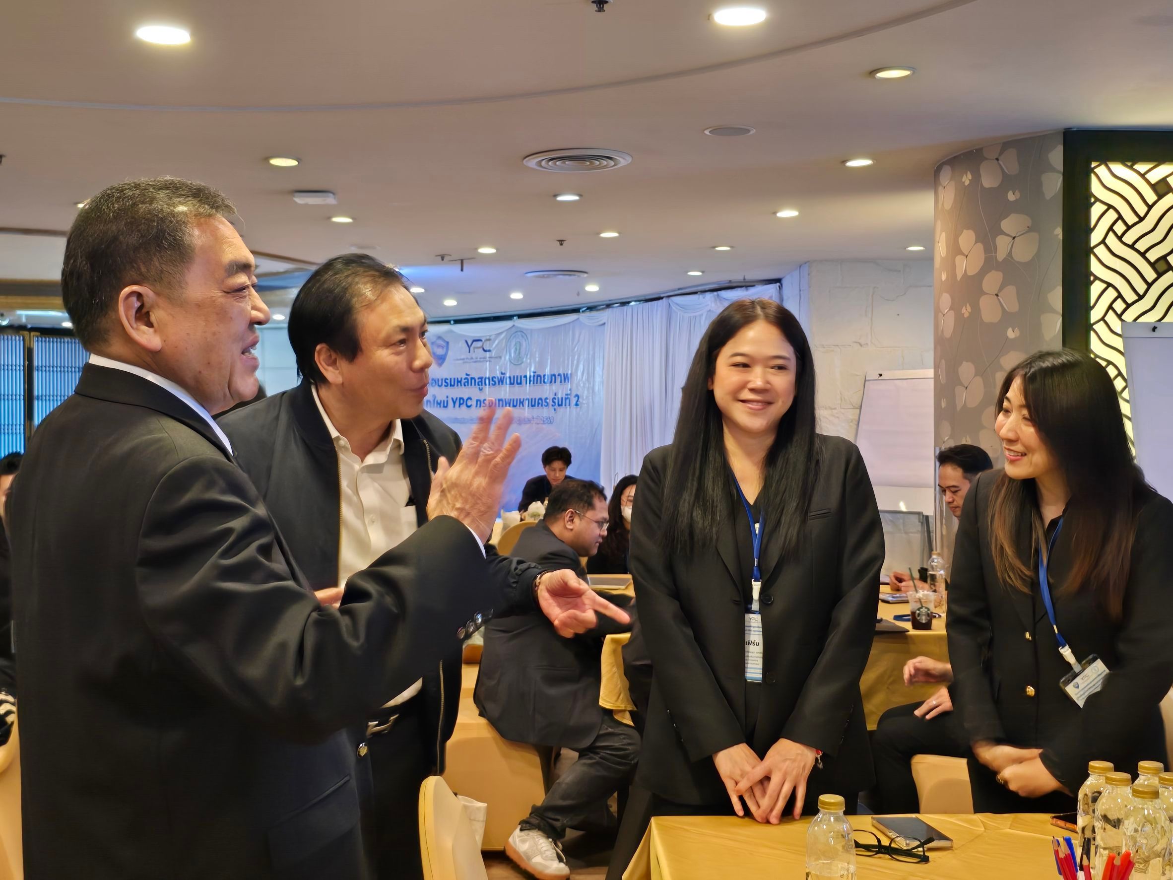 Four business professionals engaging in a lively discussion during a conference event.