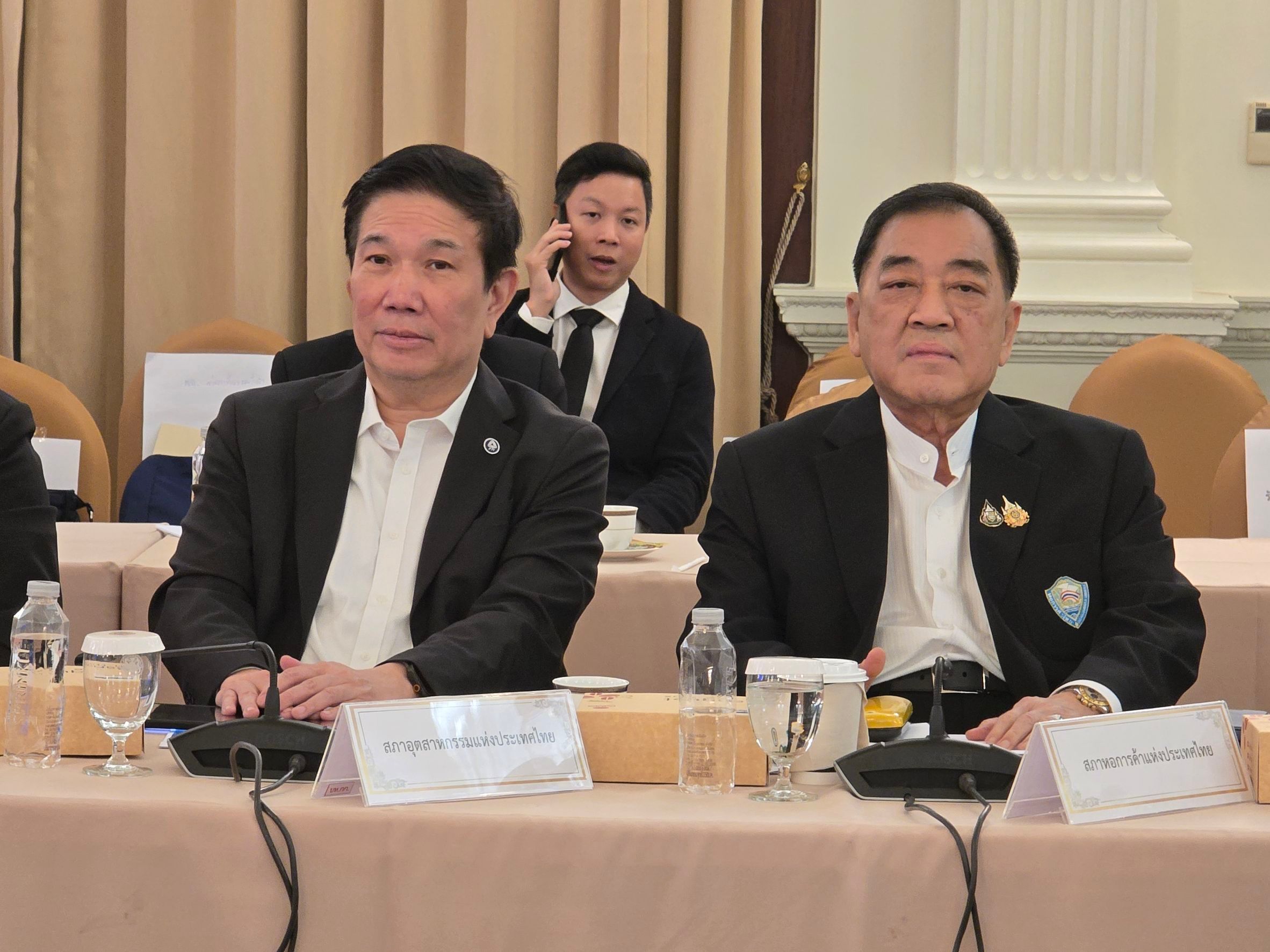Two Asian men in suits attend a formal meeting at a conference table.