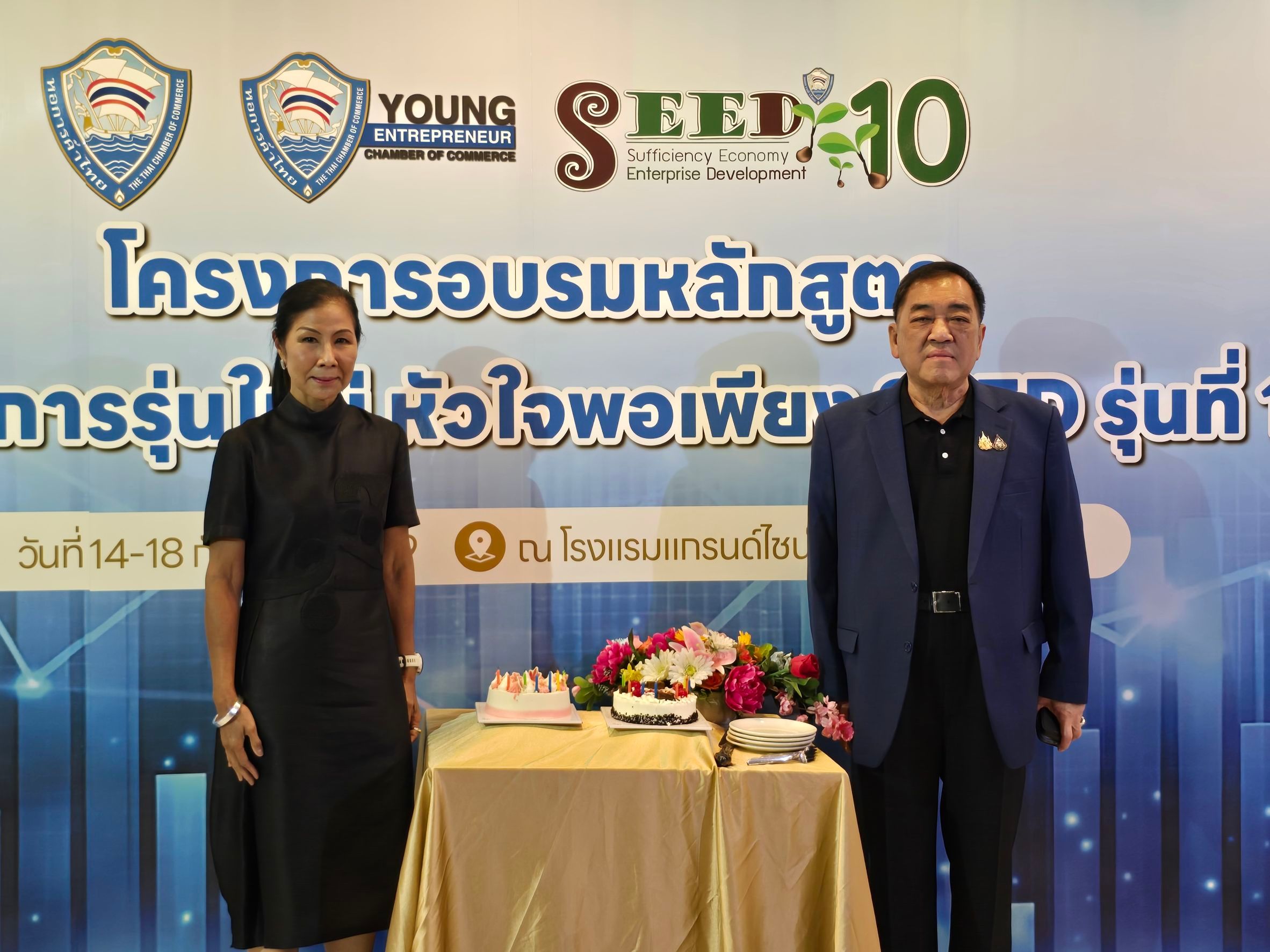A man and woman stand before a banner displaying 'YOUNG SEED 10' and Thai text.