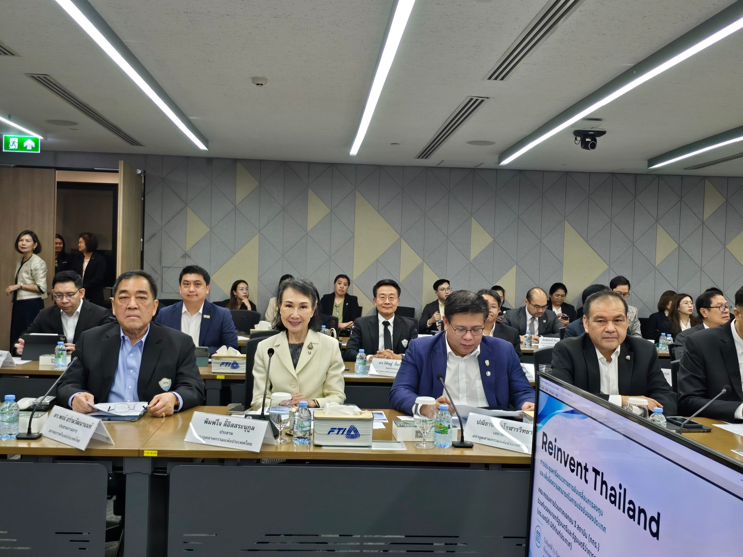 Attendees in business attire seated at a conference table during a 'Forward Thailand' meeting.
