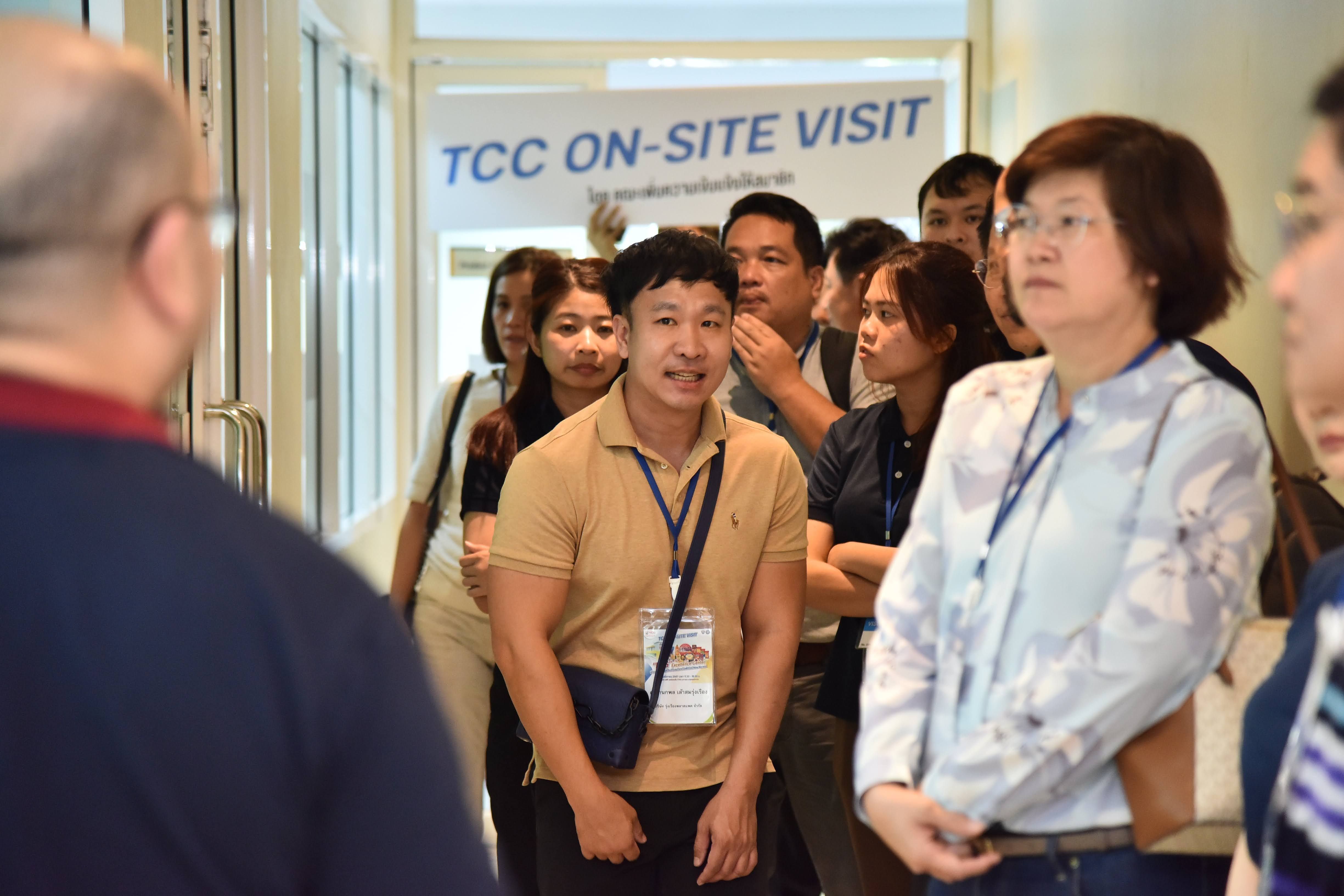 Group of professionals on a TCC on-site visit standing in a corporate hallway.