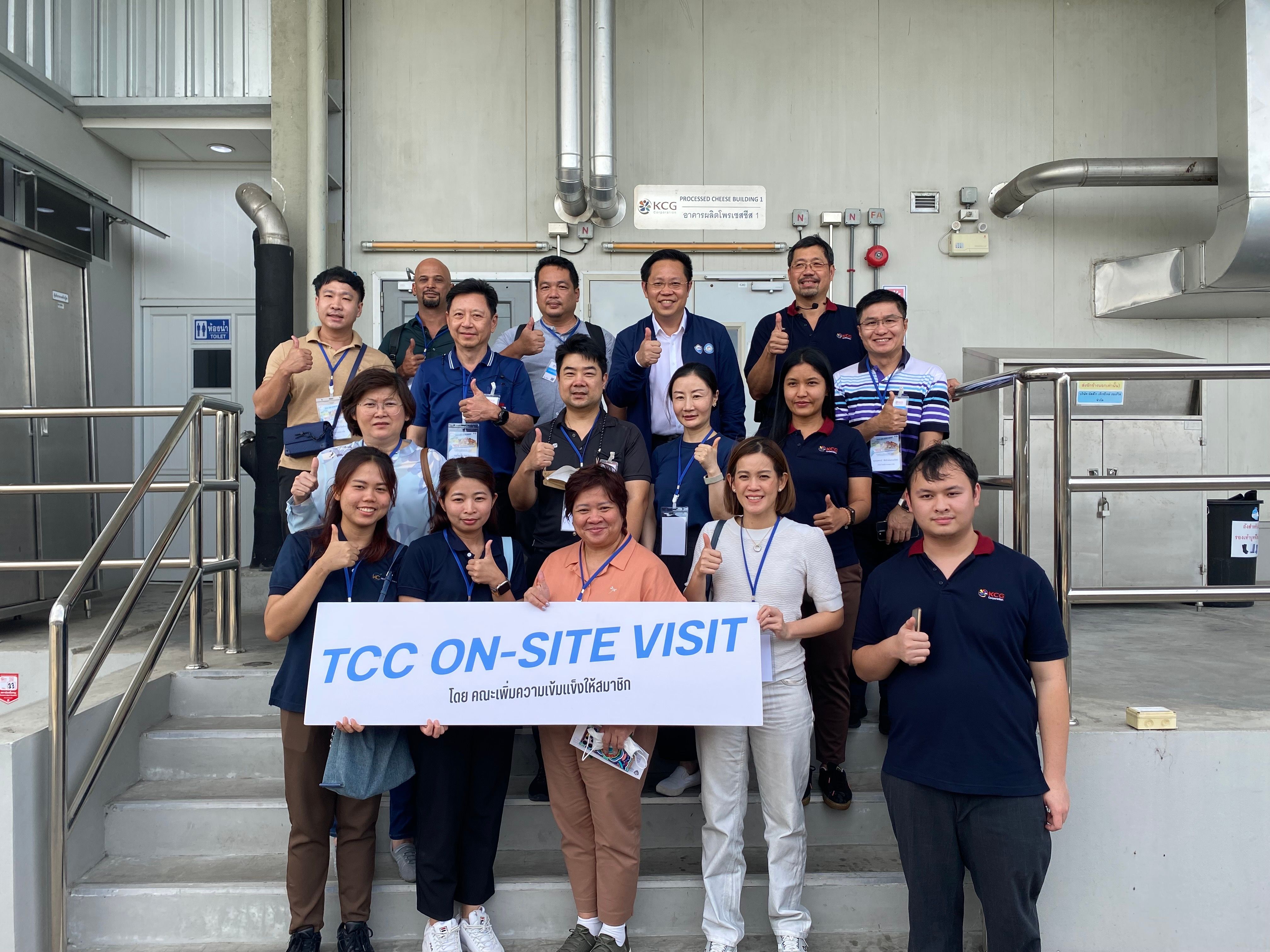 A group of professionals giving thumbs-up during a TCC on-site visit at an industrial facility.