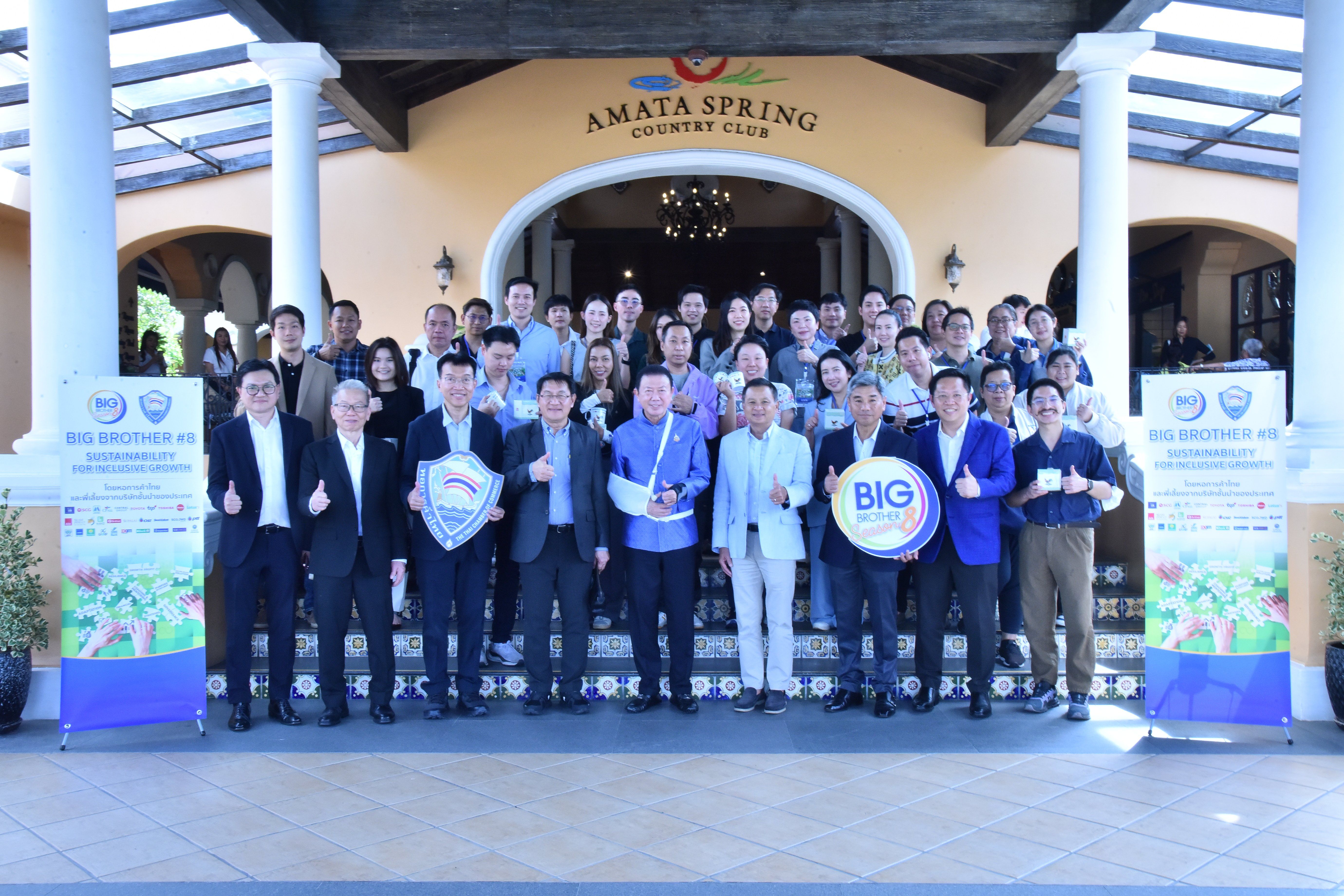 Large group holding awards in front of Amata Spring Country Club building.