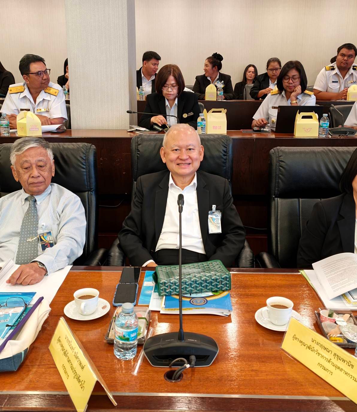 Professionals seated at a conference table, with one man smiling at the camera.