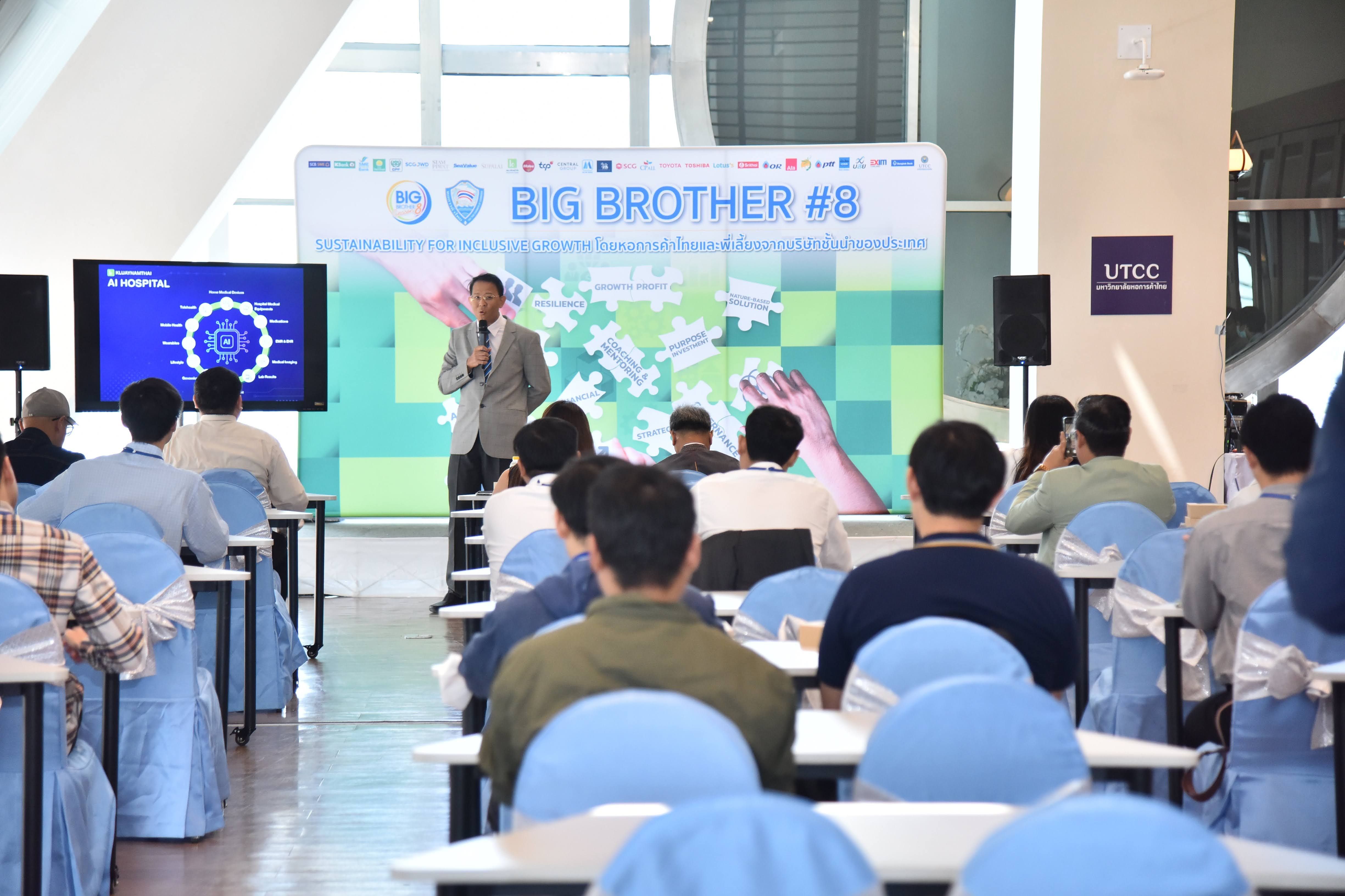Man speaking at a conference with a large screen displaying 'BIG BROTHER #8' to an audience.