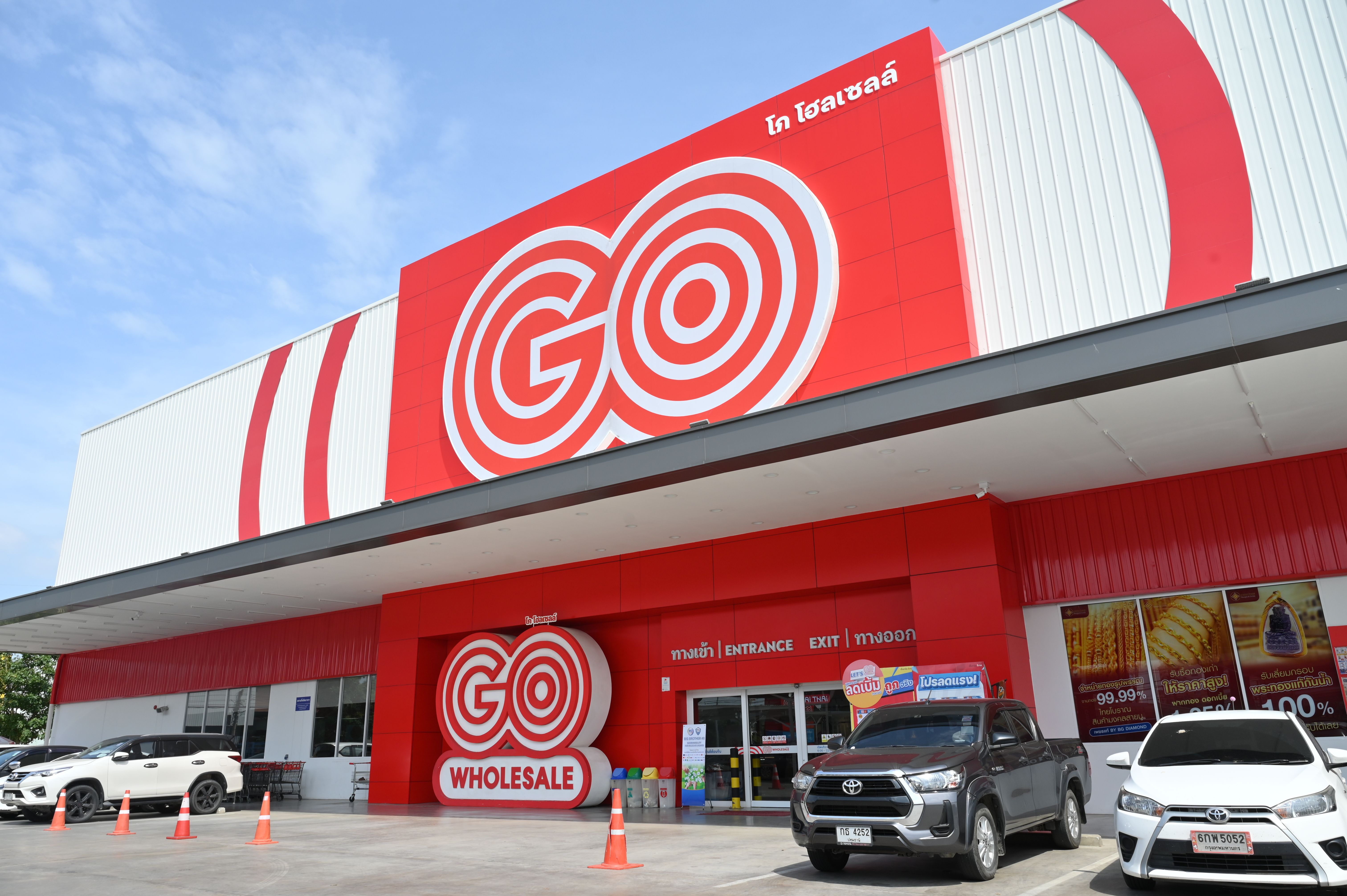 Exterior view of a Go Wholesale store with prominent red and white signage.