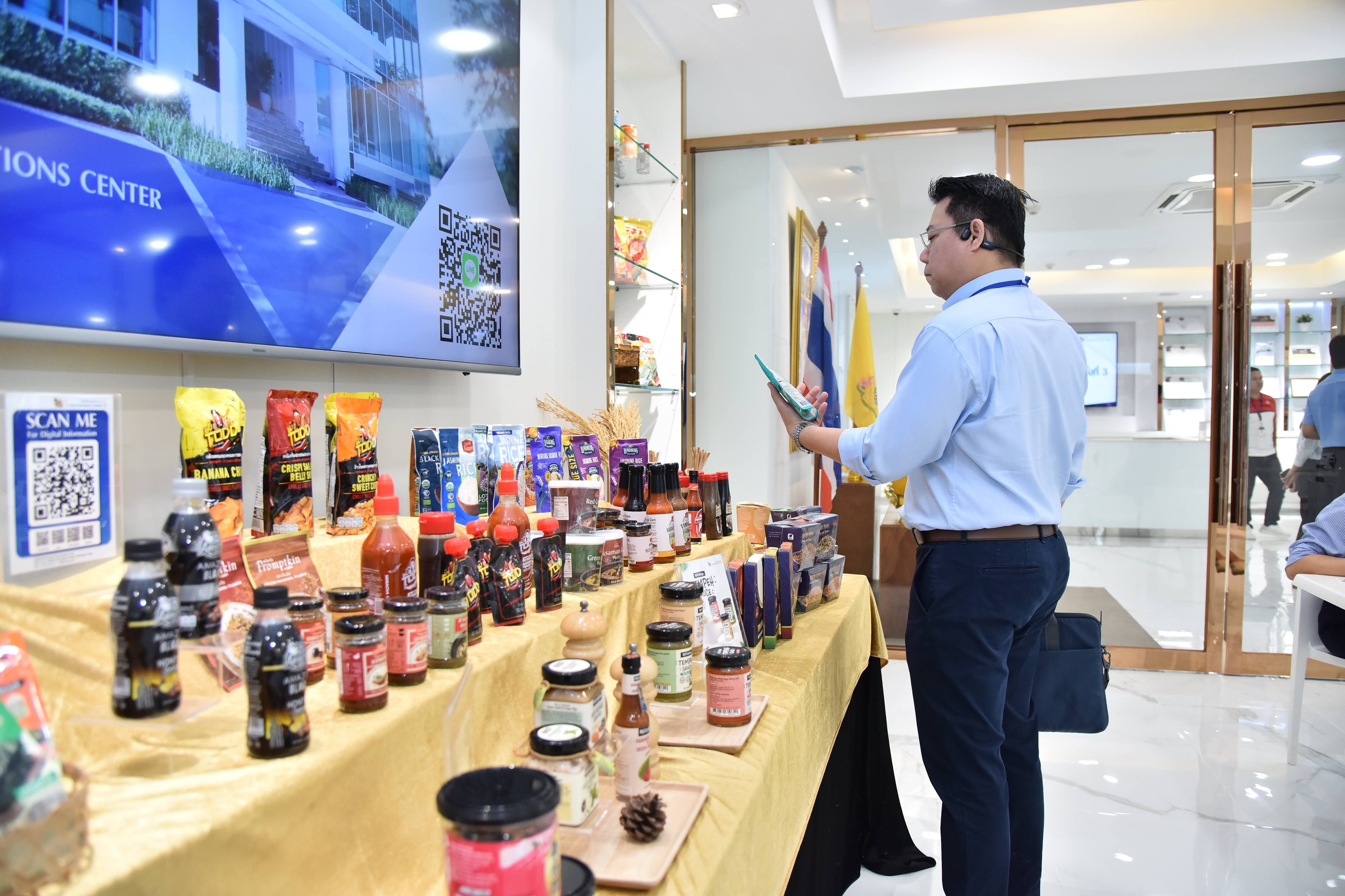 A man examines a display of various packaged food and drink products in a modern setting.