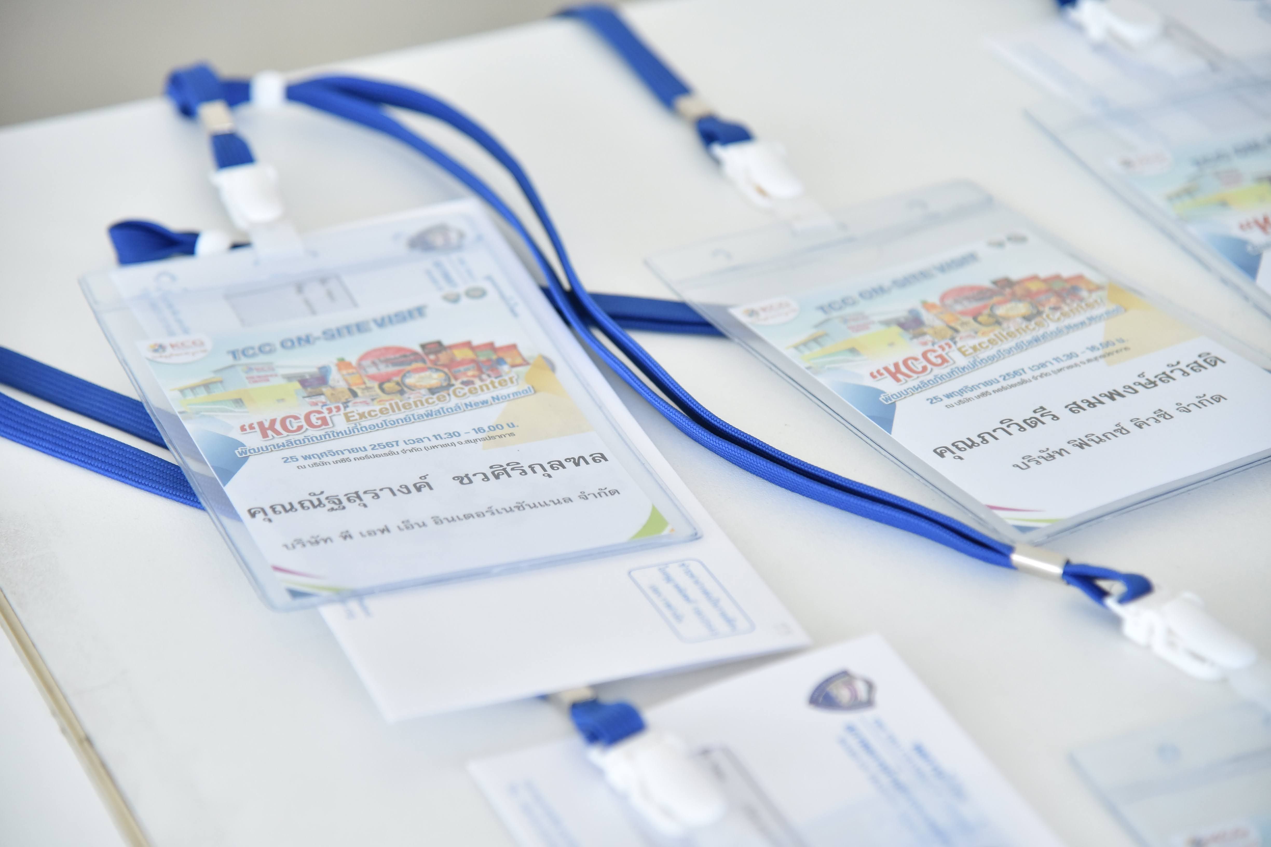 Several event badges with blue lanyards are neatly arranged on a white surface.