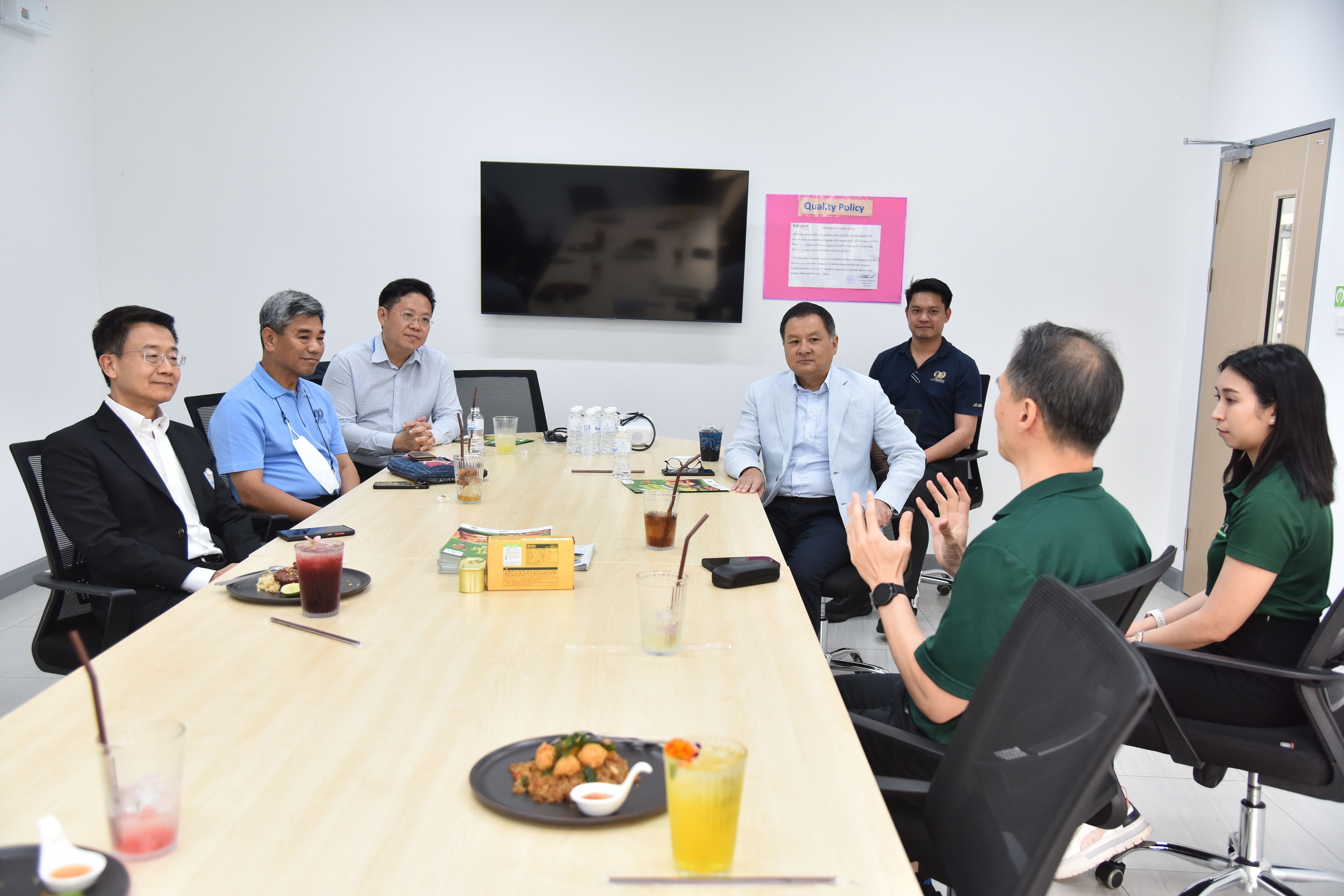 Professionals discuss ideas around a conference table in a bright, modern meeting room.