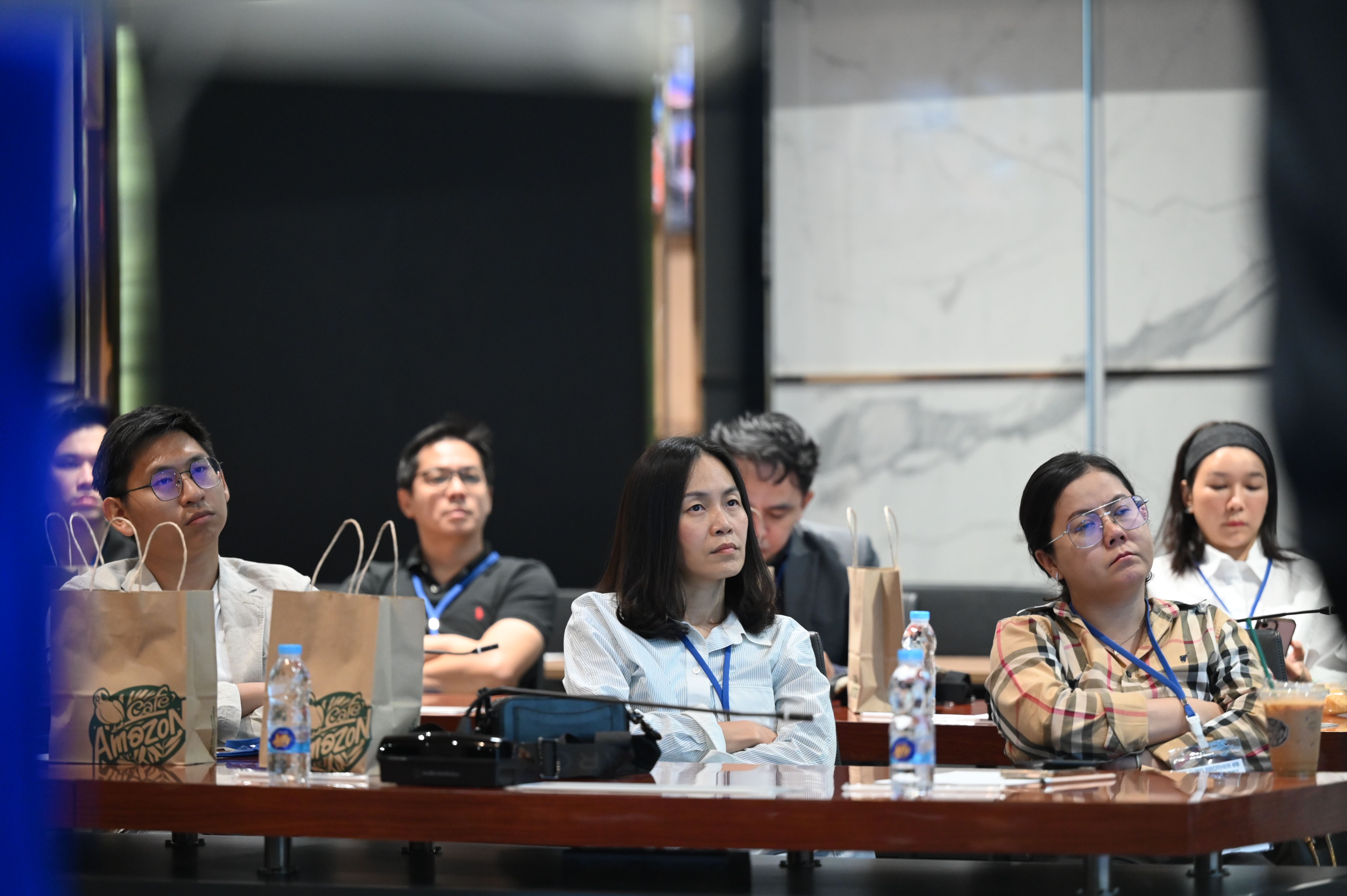 Group of diverse professionals attentively listening at a conference session indoors.