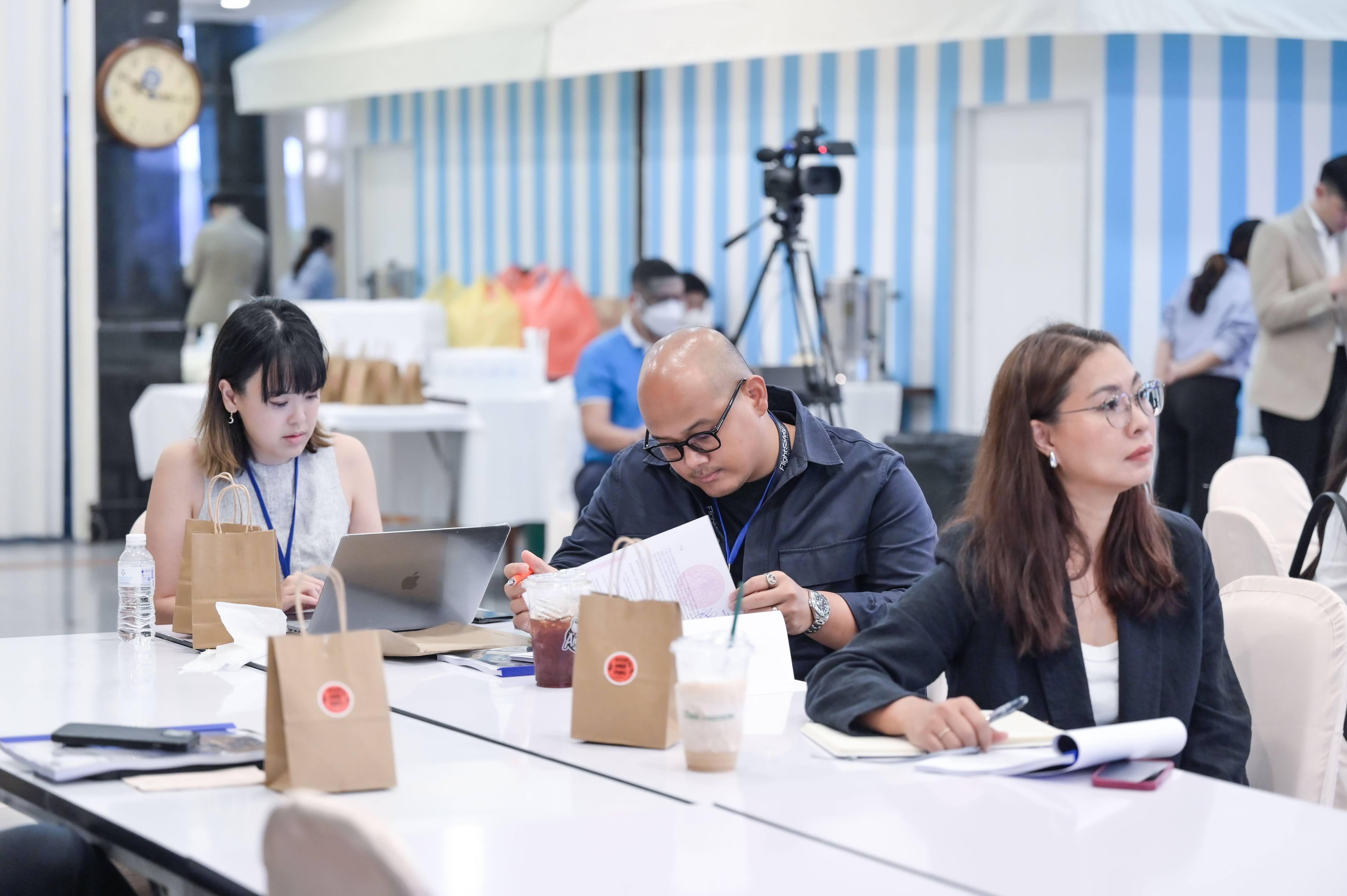 Three professionals, two women and a man, engaged in a focused workshop session.