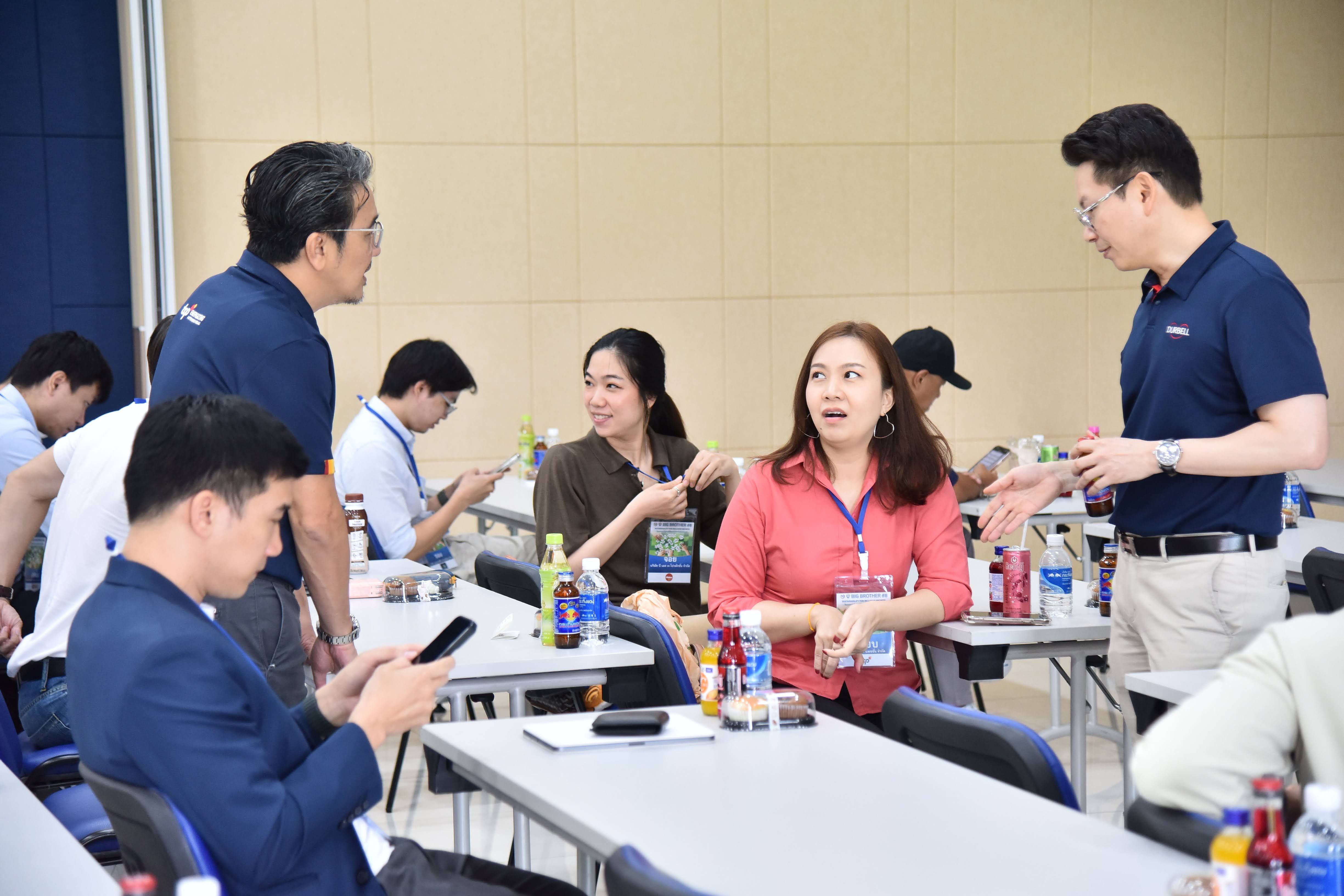 Professionals networking at an event, with some standing and others seated, engaging in conversation.