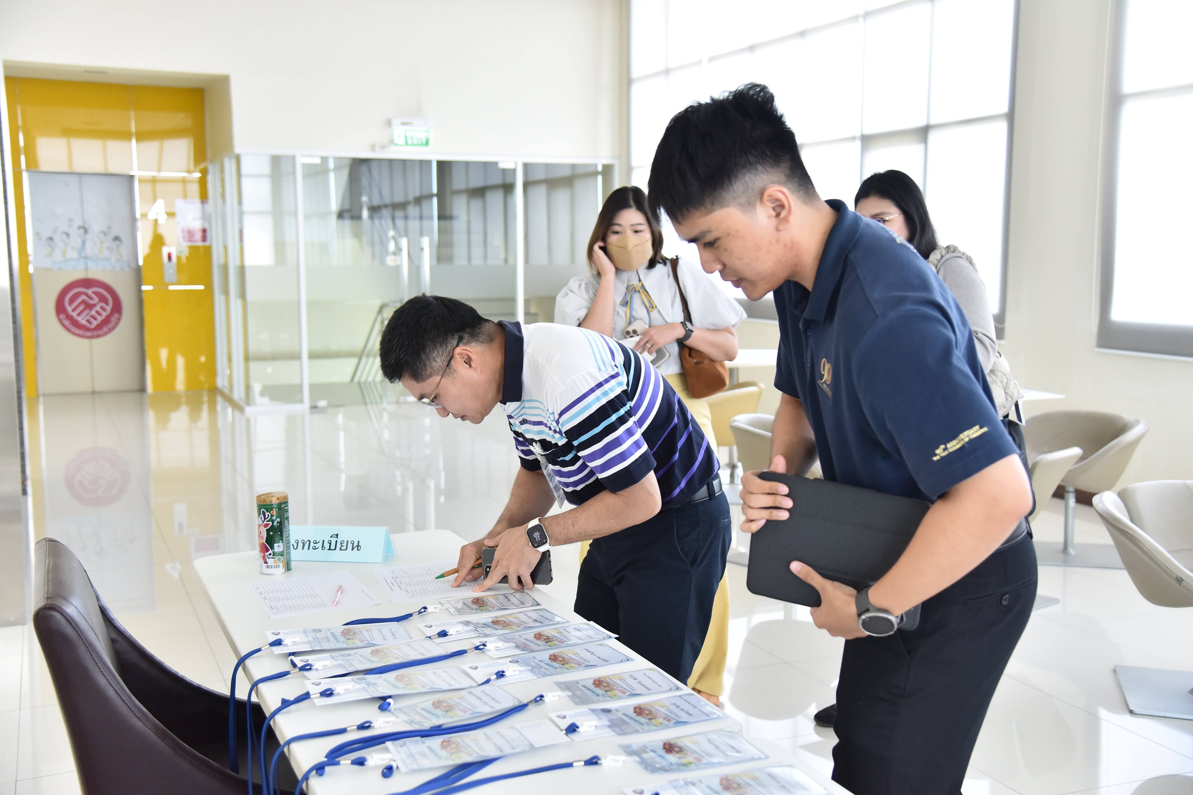 Two men register at a table displaying lanyards during an event check-in process.