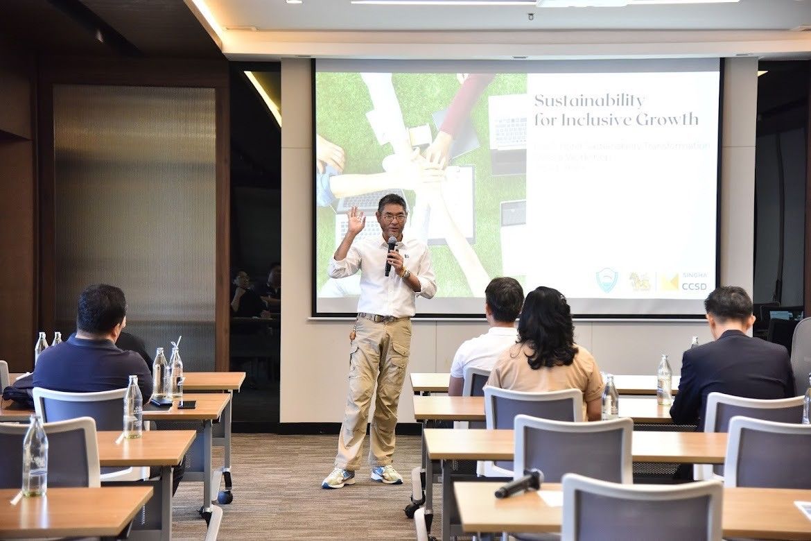 Man presents on sustainability to an audience with a 'Sustainability for the Earth's Growth' slide.