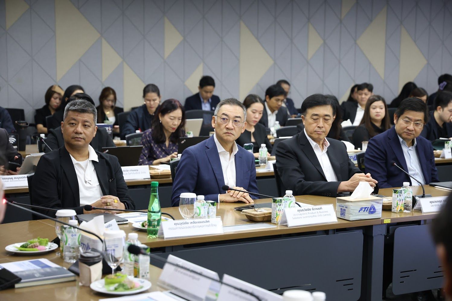 Business professionals attending a meeting at a large conference table.