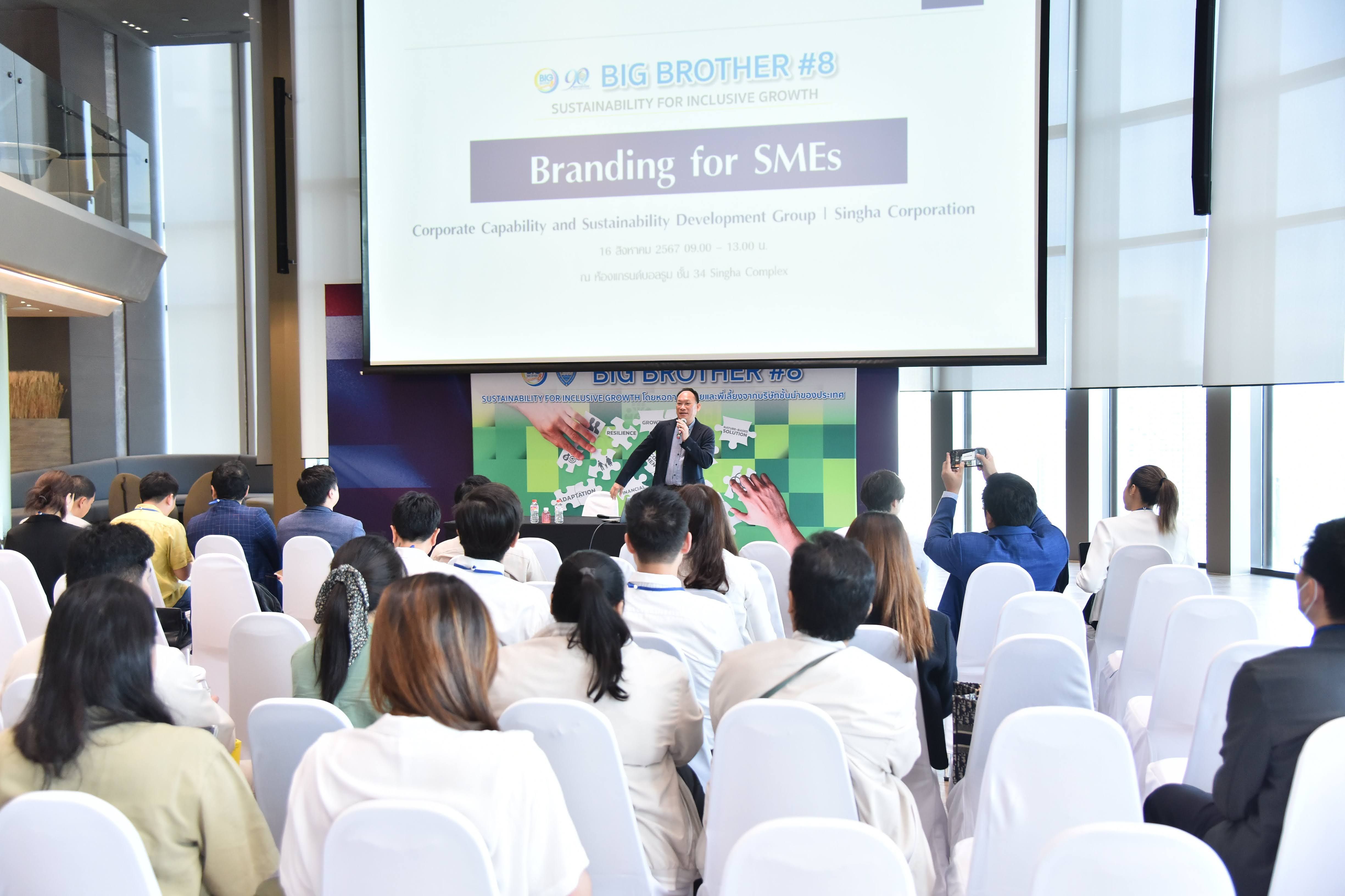 Speaker presents "Branding for SMEs" to a seated audience at a seminar.