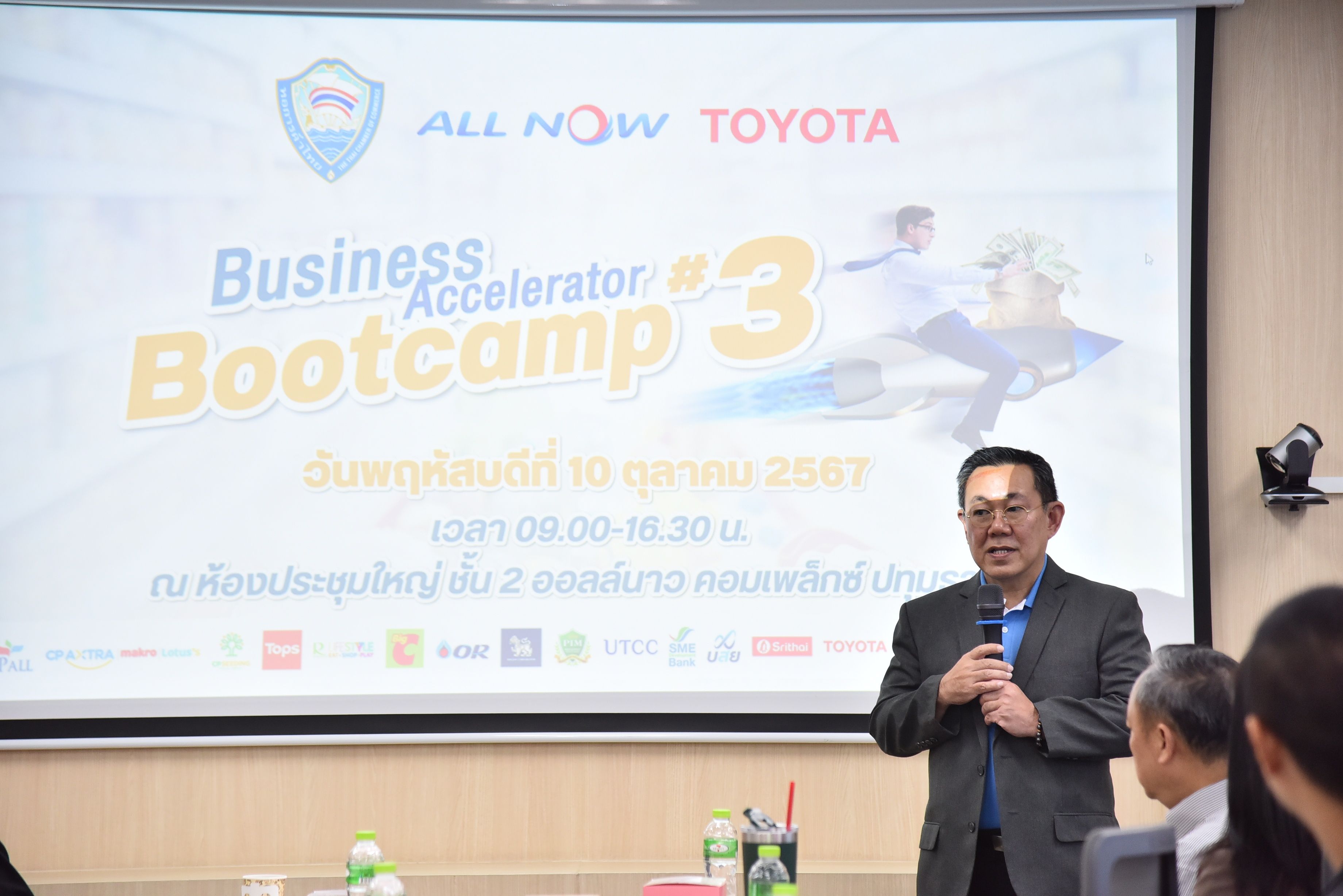 Man presenting at Business Accelerator #3 Bootcamp event, with Toyota and ALL NOW logos.