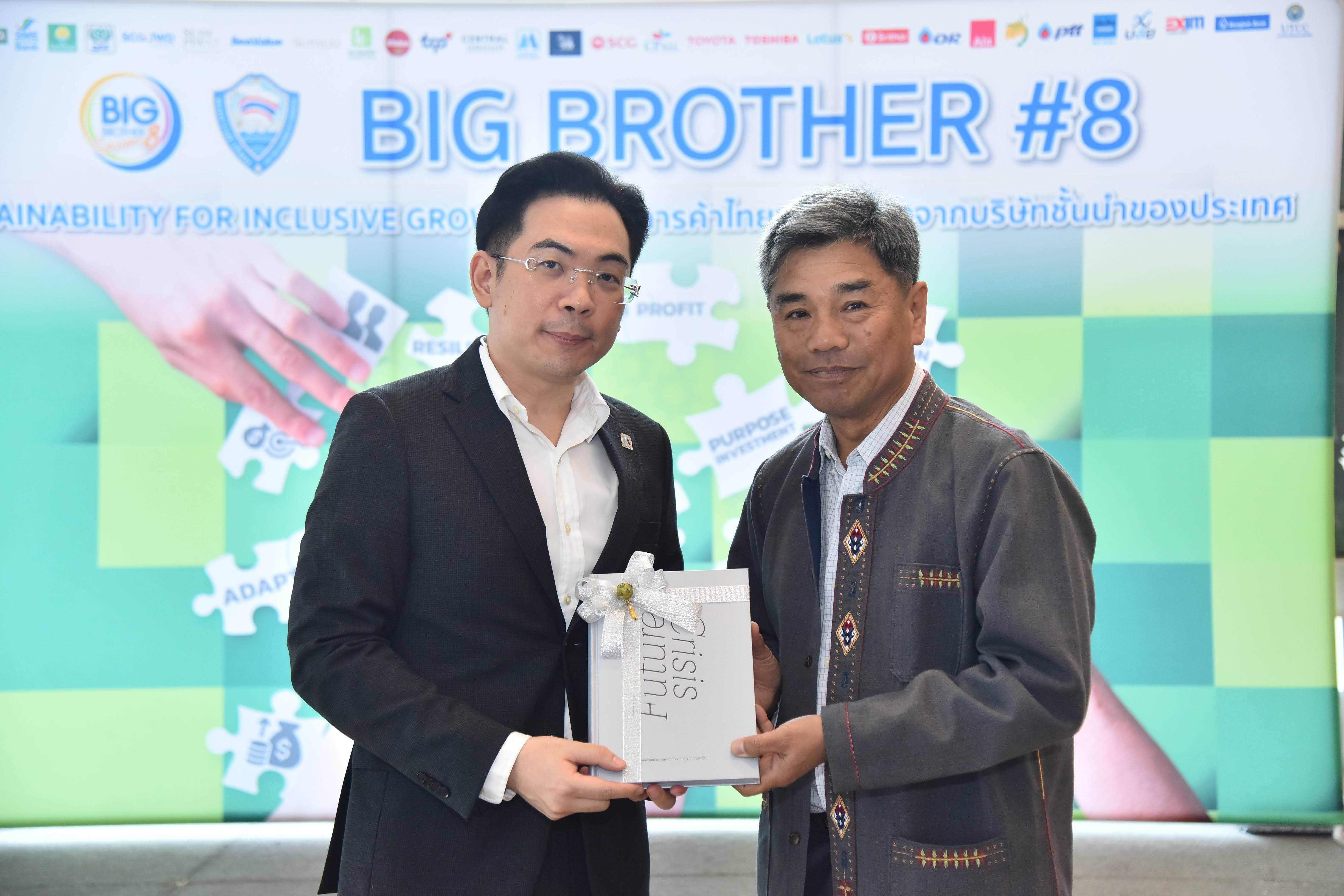Two men holding a white gift box, standing before a "BIG BROTHER #8" screen.