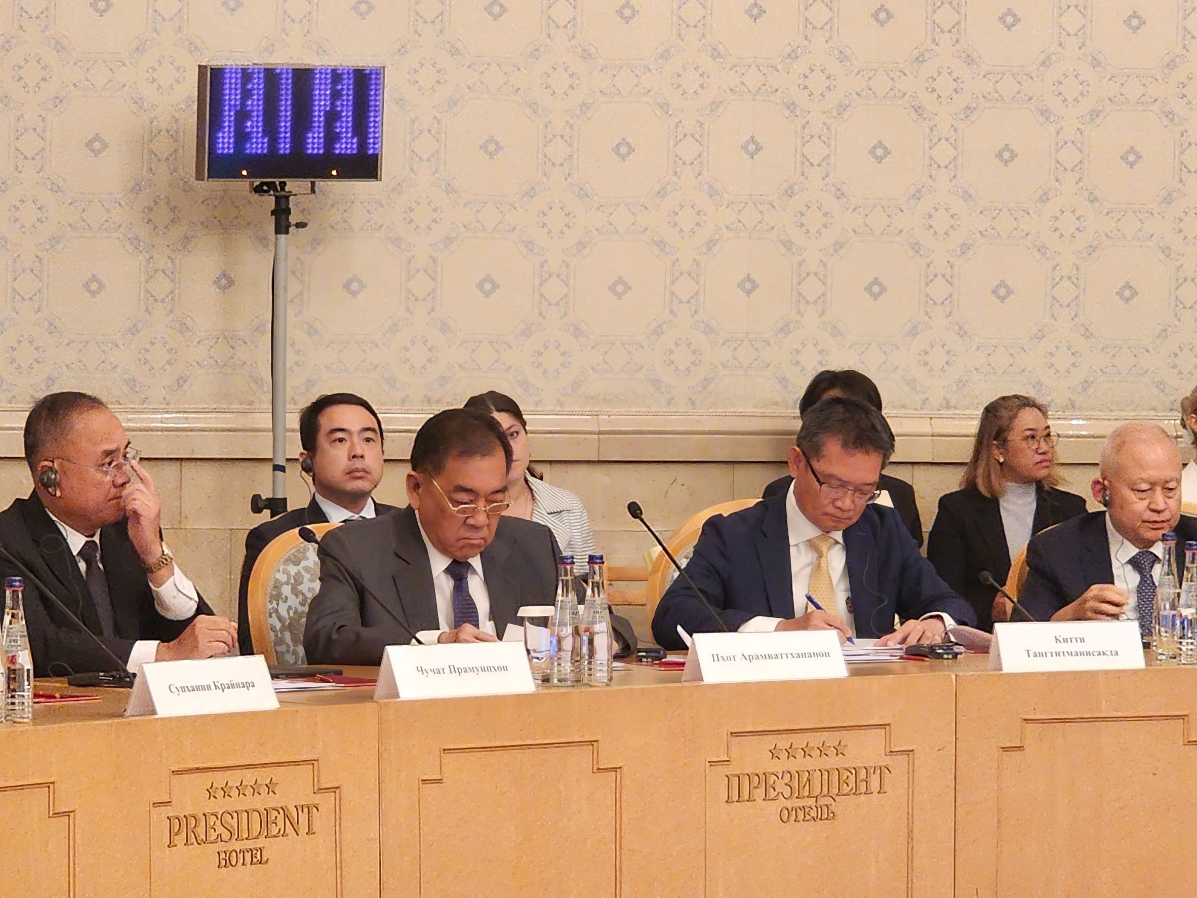 Officials in suits participate in a high-level international conference meeting.