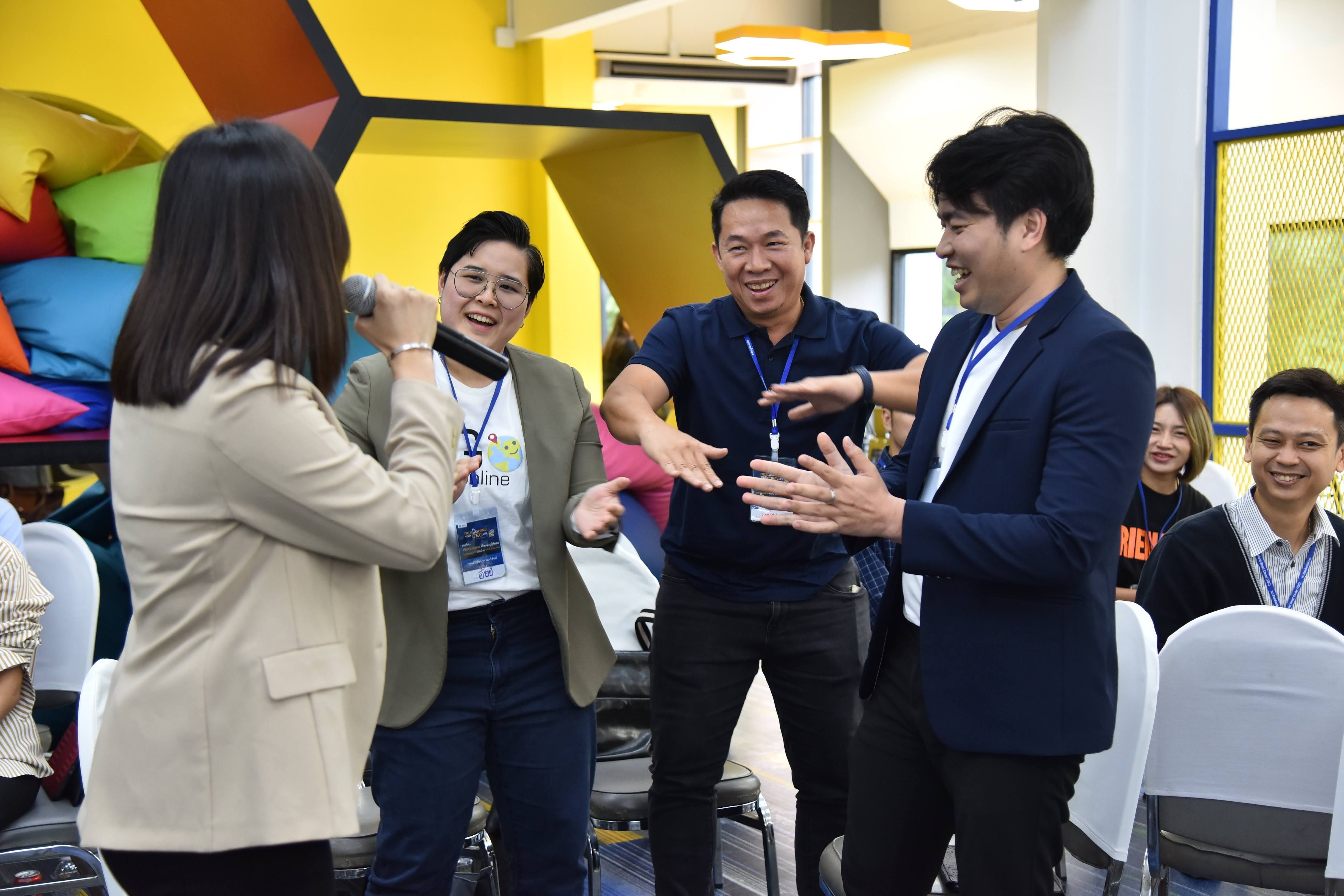 A woman interviews three laughing men, engaging them in a lively indoor session.