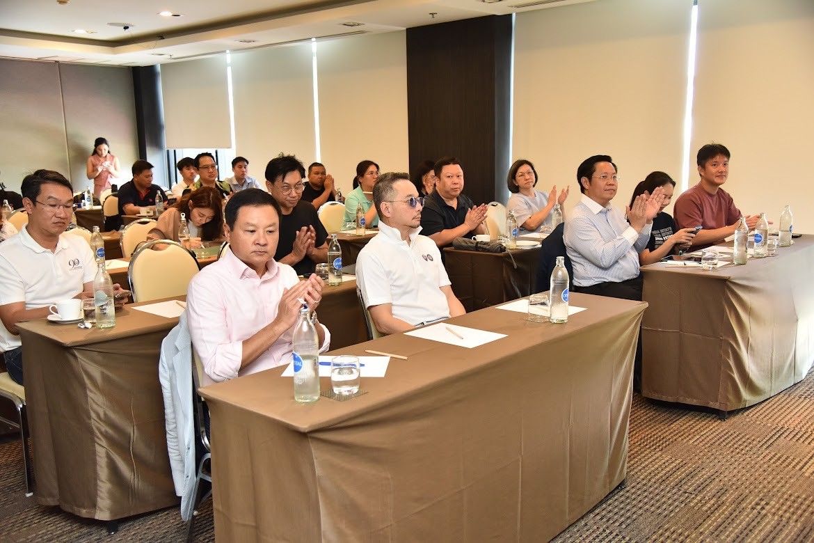 Audience members clap during a presentation in a modern conference room.