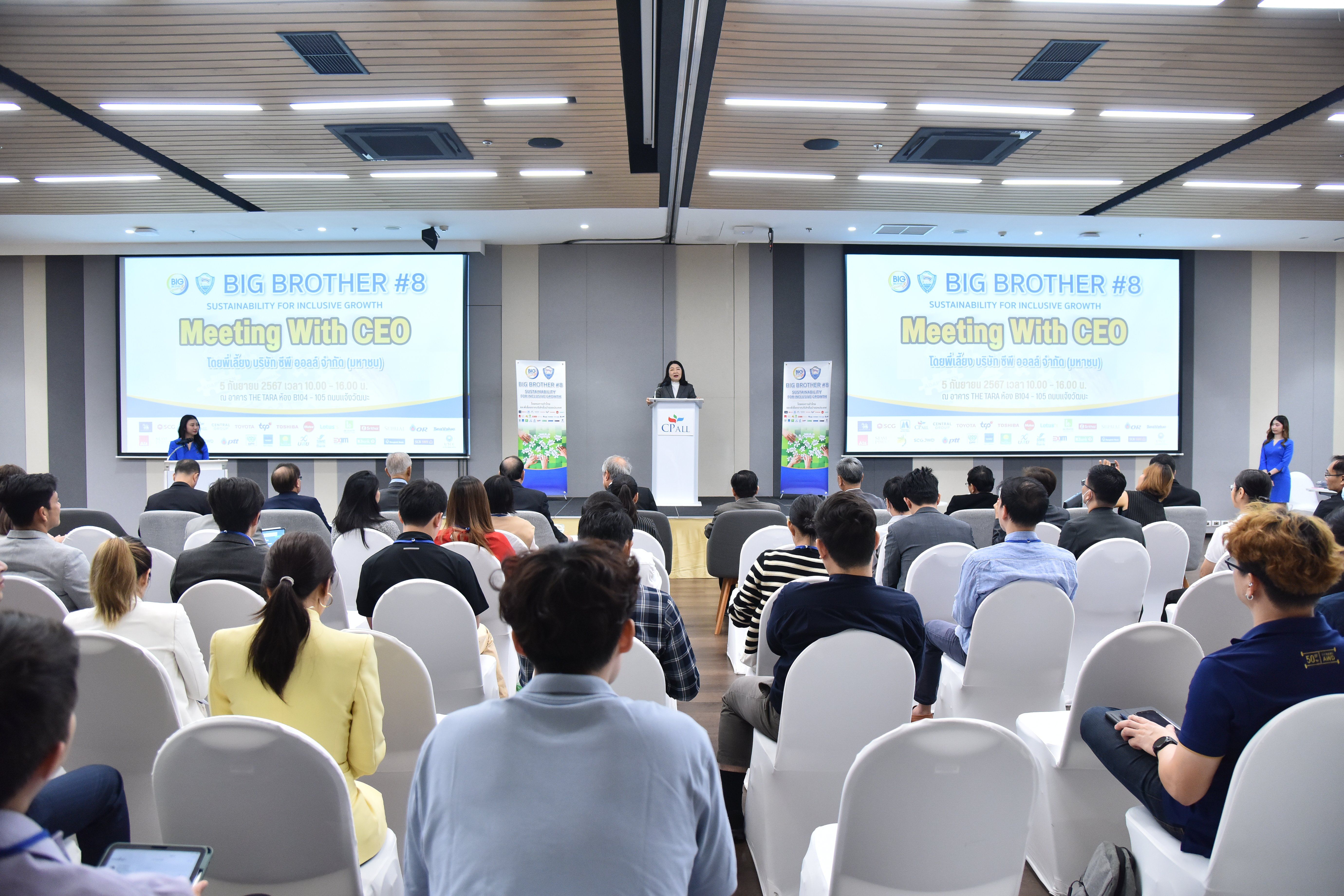 A speaker addresses a large audience at a conference displaying 'BIG BROTHER #5 Global Health' on screens.