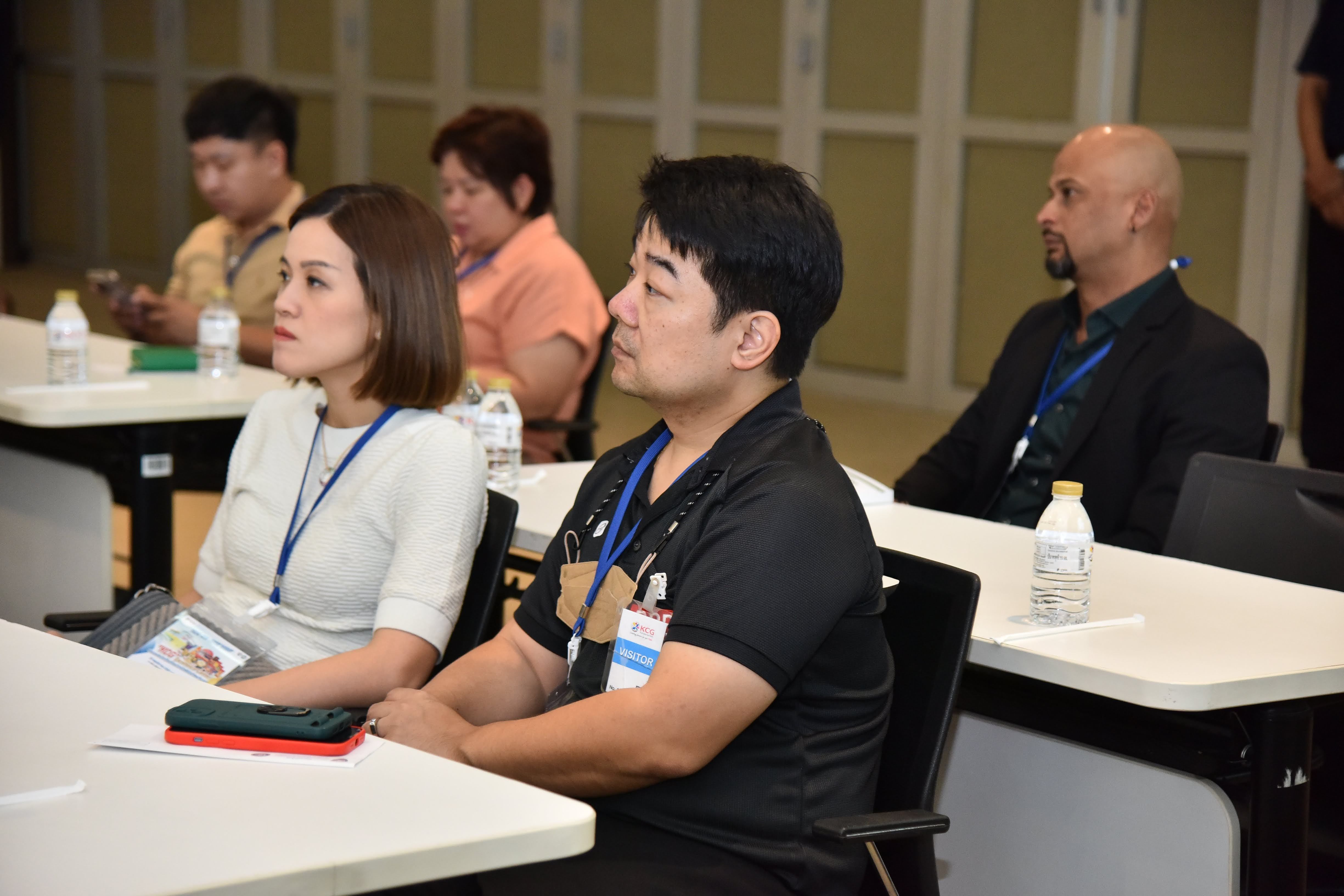 Diverse attendees intently listen during a professional conference session.