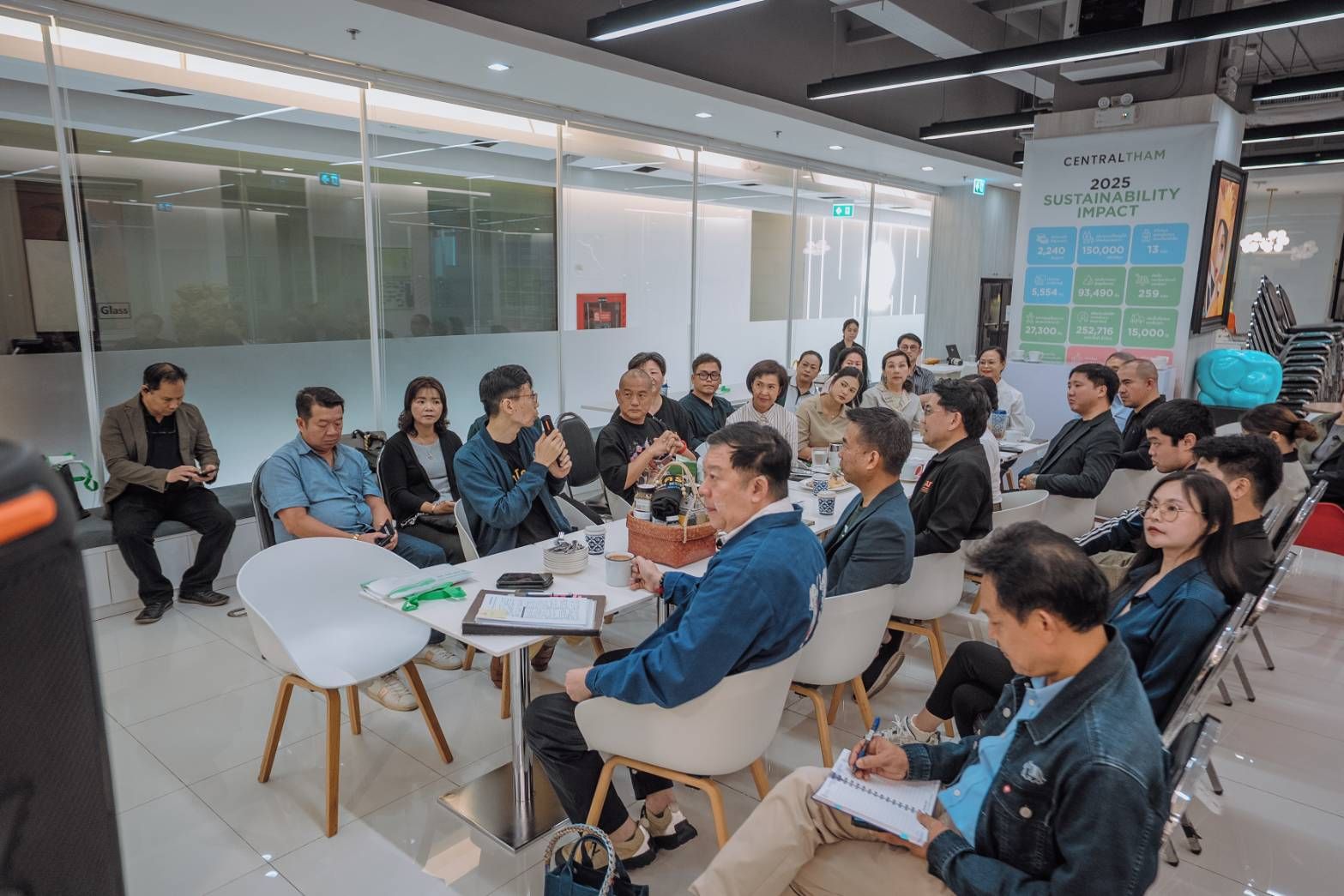 Group of professionals discussing in a modern meeting room, one person speaking.