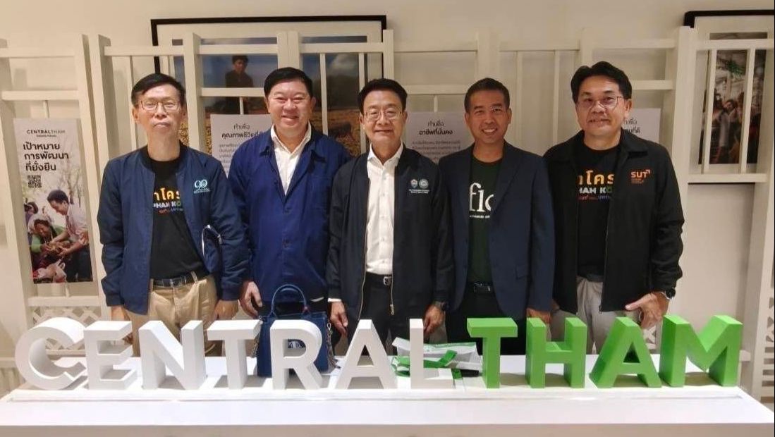 Five men stand behind a white "CENTRAL THAM" sign with Thai text in the foreground.