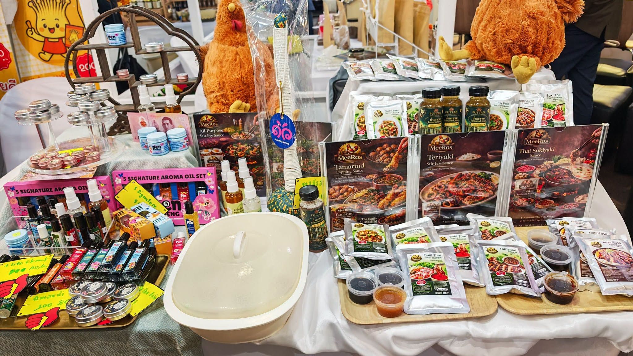 A market stall displays an assortment of packaged food products, sauces, and snacks with chicken decorations.