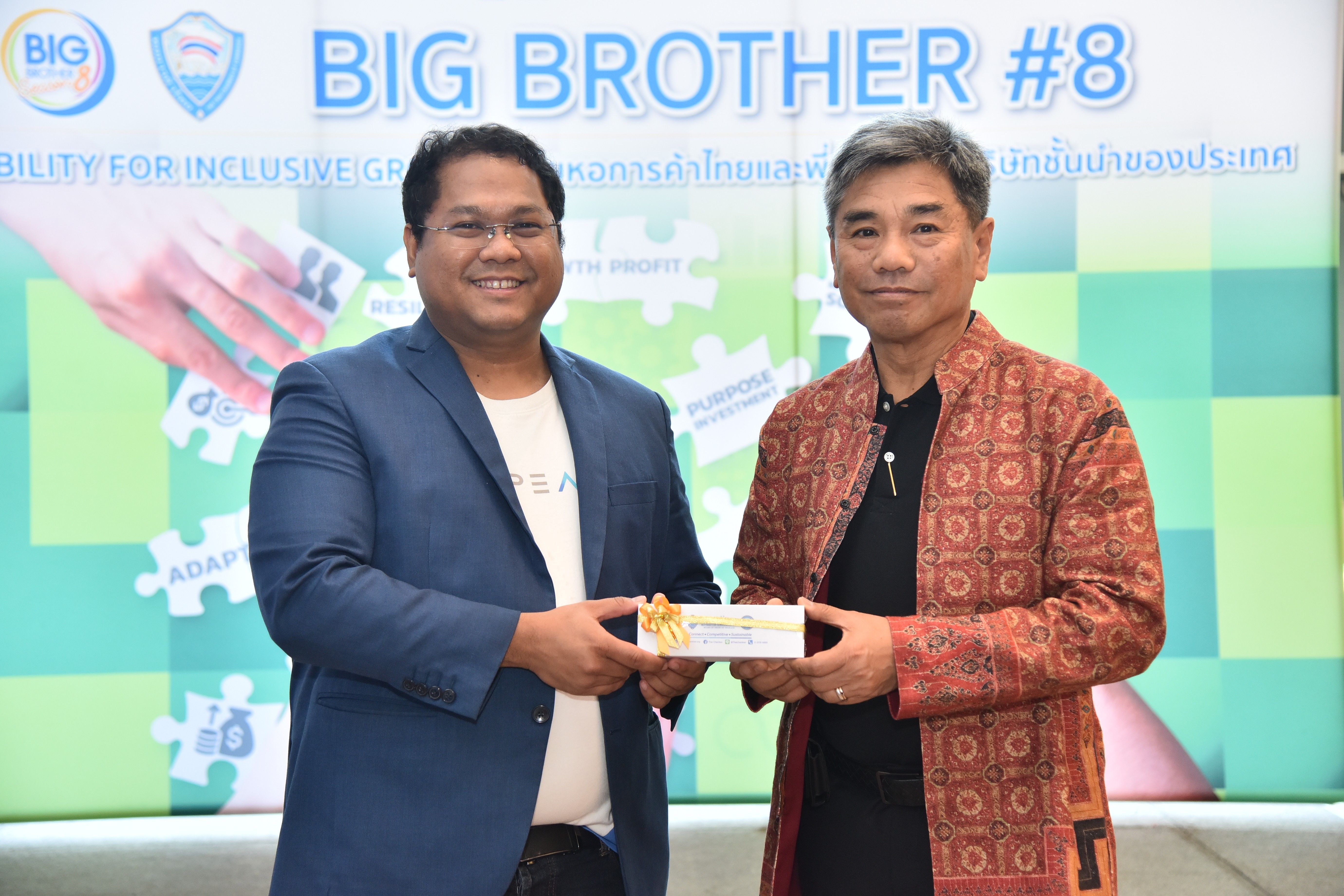 Two men exchanging an award at a "BIG BROTHER #8" event.