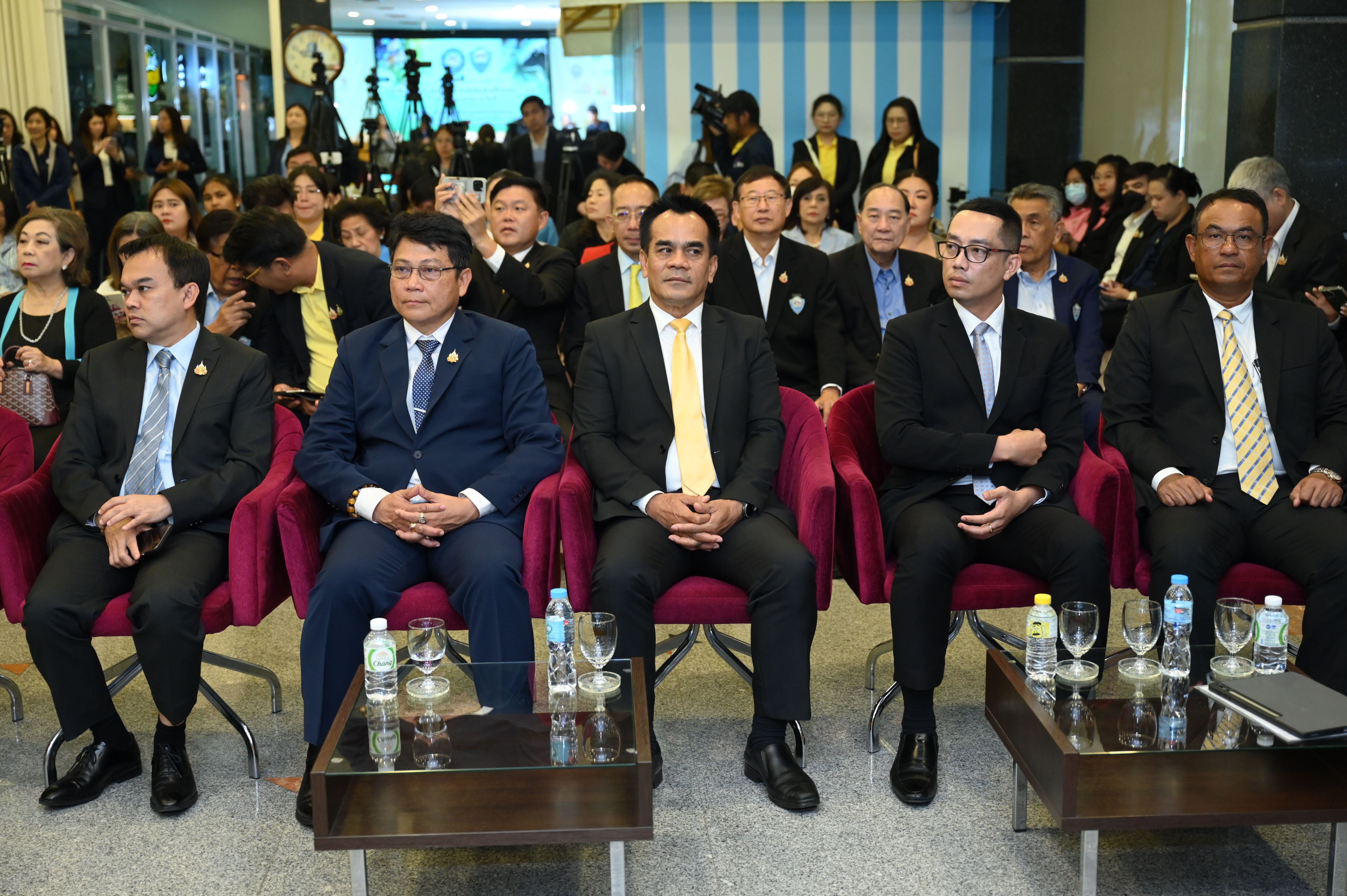 Group of formally dressed men sitting in the front row at a conference event.