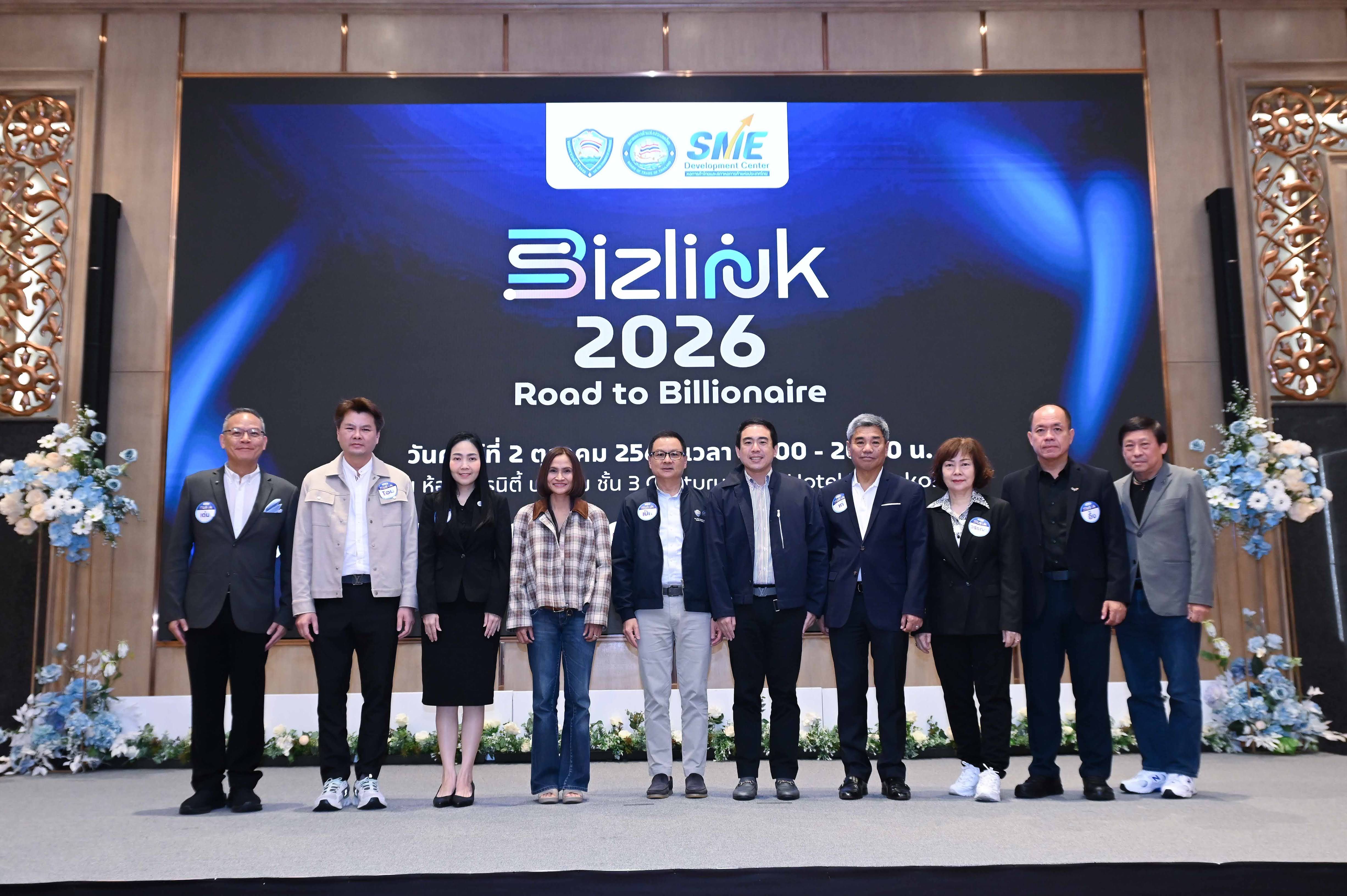 Ten people pose on a stage with a screen showing 'BiZlink 2026 Road to Billionaire'.